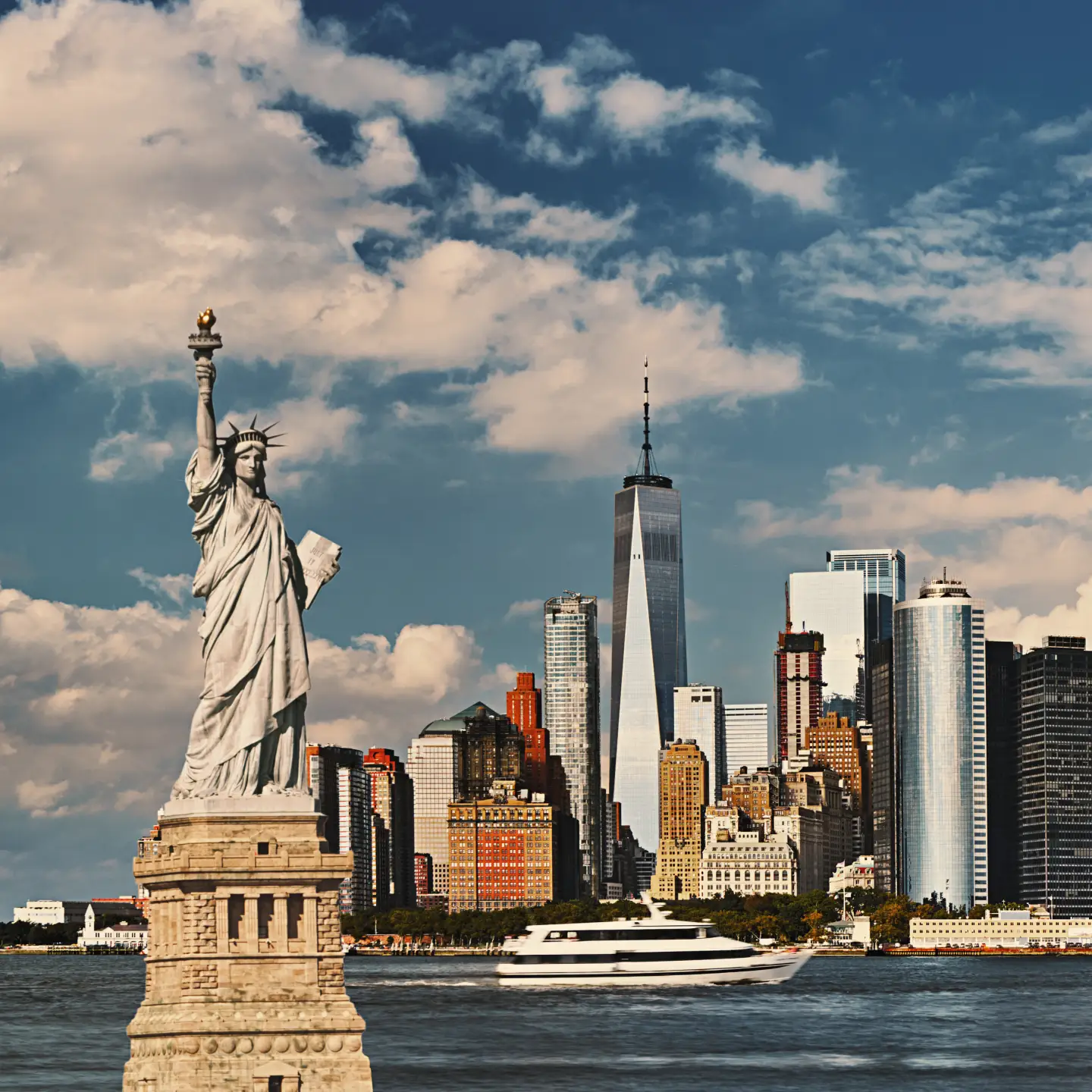A New York-i Szabadság-szobor a manhattani látkép előtt, tiszta kék ég alatt.