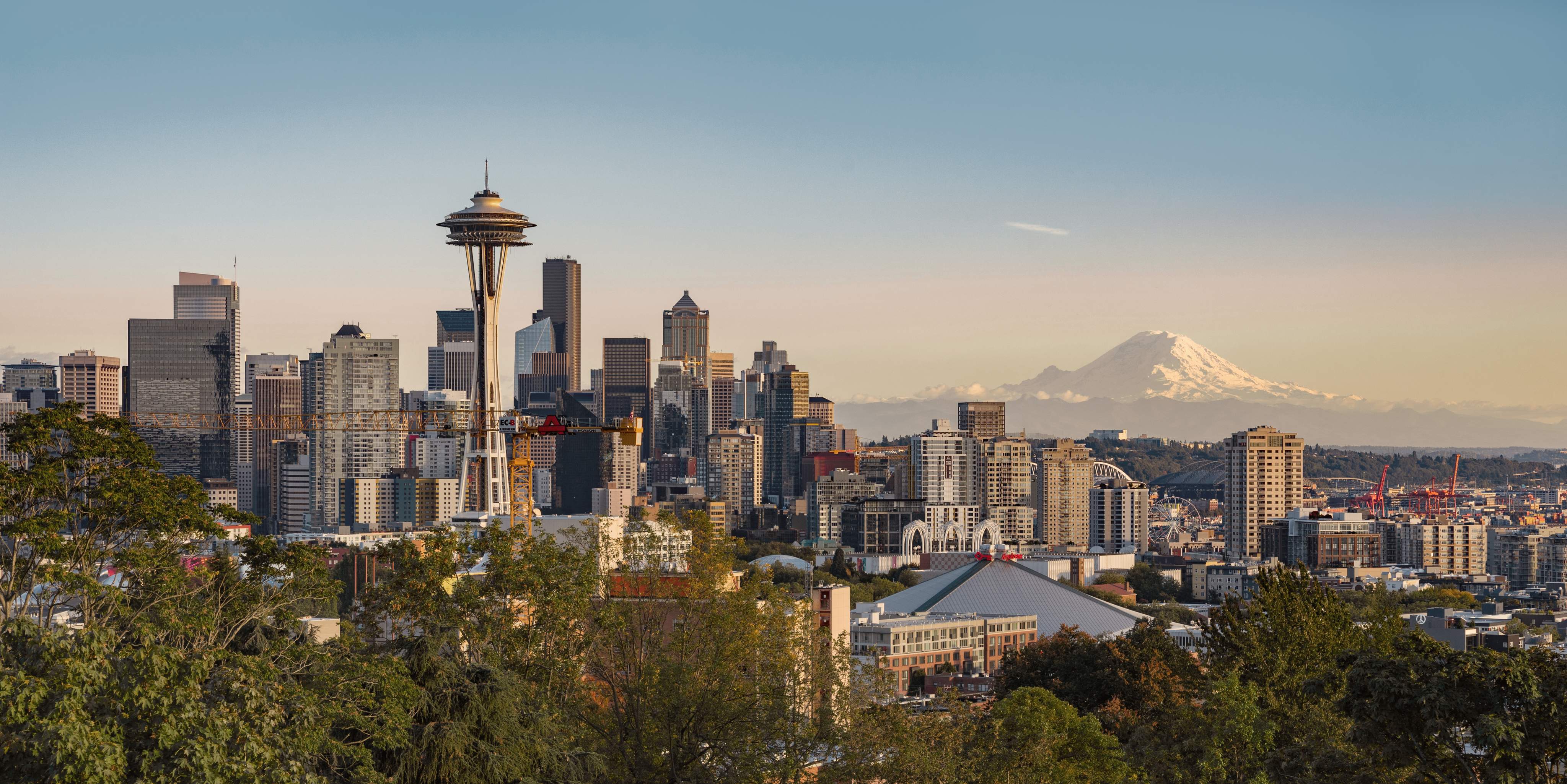 View of the skyline of Seattle, Washington, with the Space Needle in the foreground and Mount Rainier in the background.