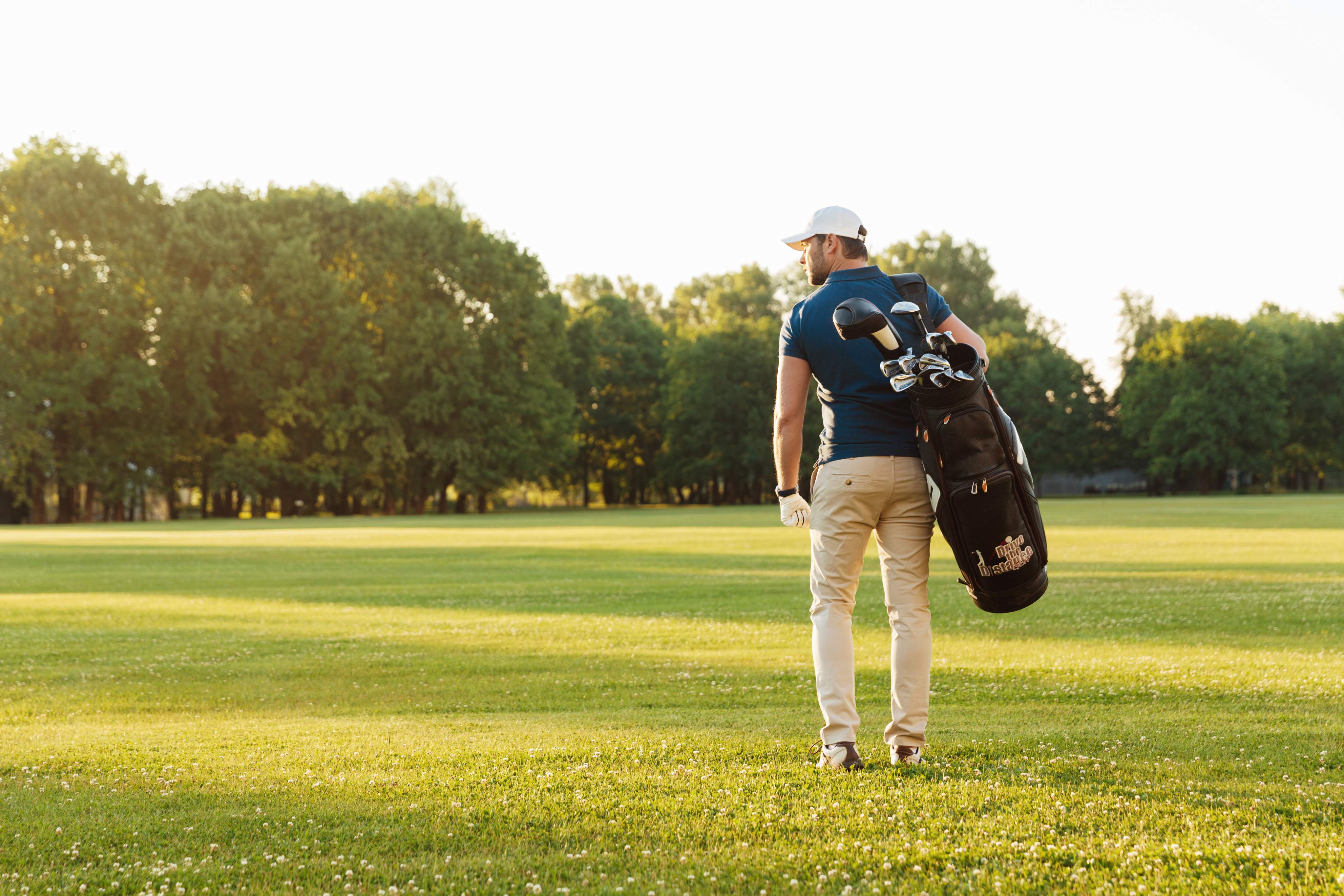 Golfista con bolsa de golf en un campo