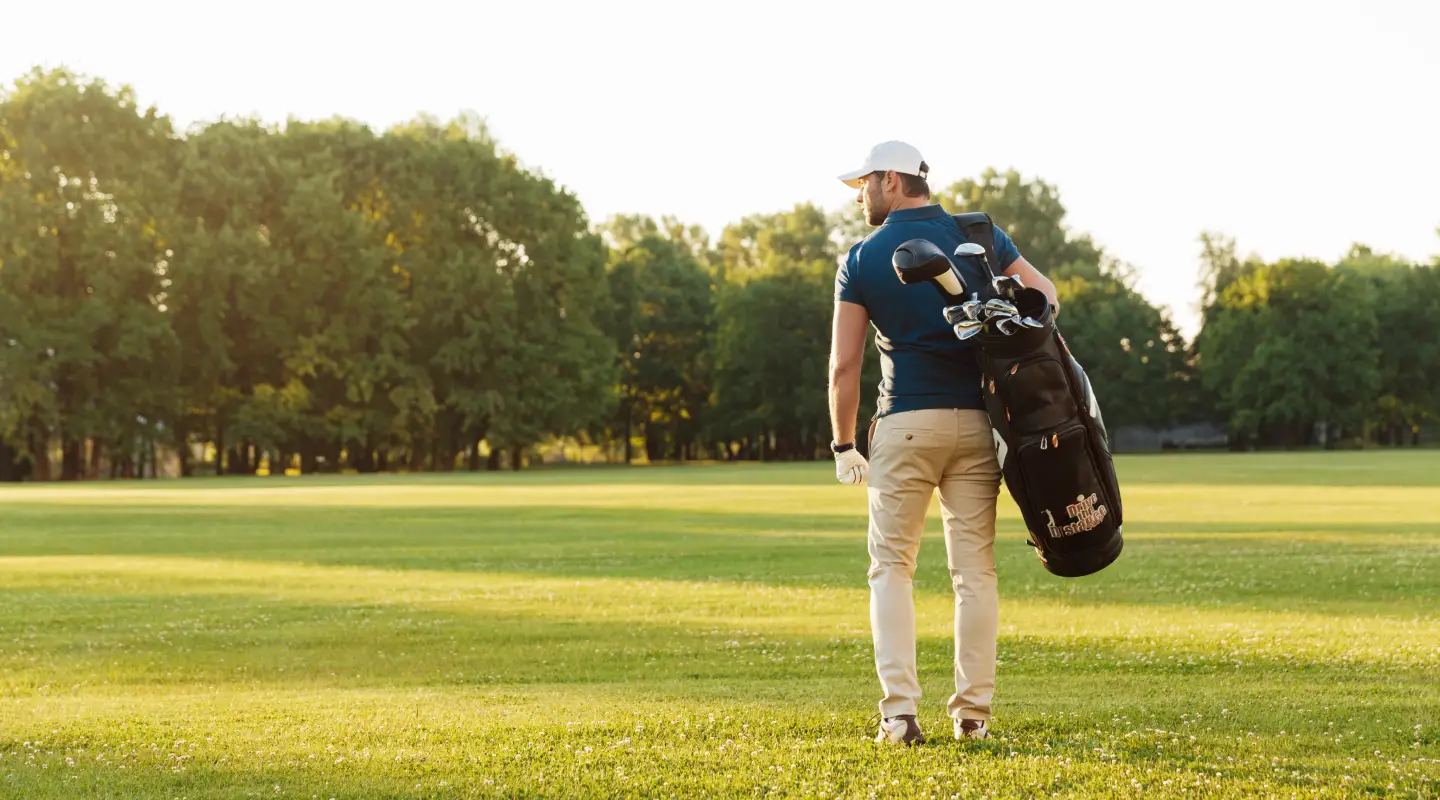 Golfista con bolsa de golf en un campo