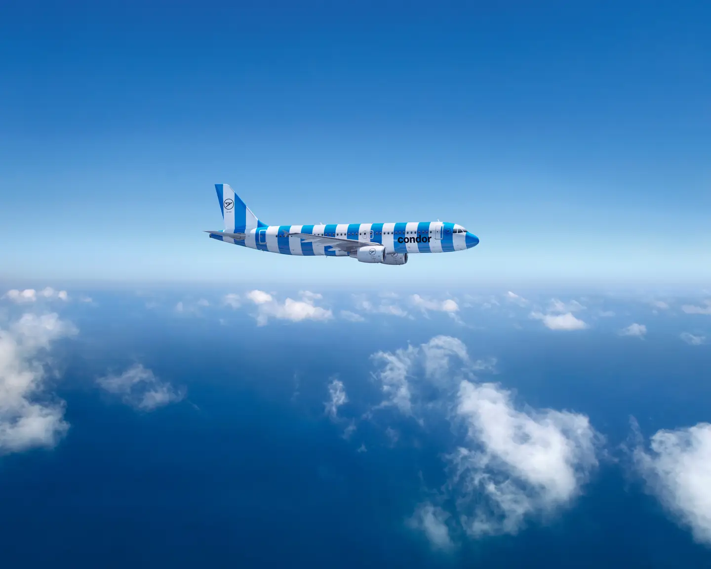 Un Airbus A320-200 de Condor con rayas verdes y blancas sobre un cielo azul claro, con finas nubes blancas debajo.
