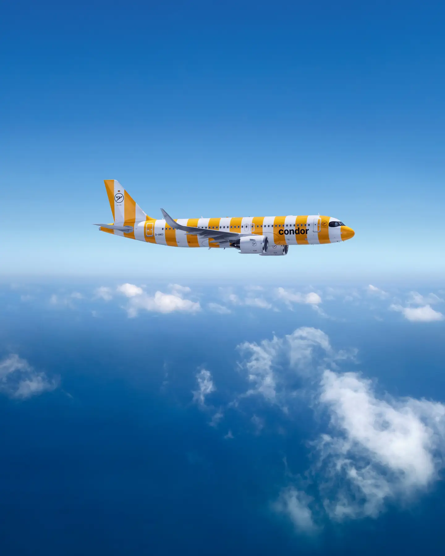 Airbus A320-200 de Condor frente a un cielo azul claro, con finas nubes blancas debajo.