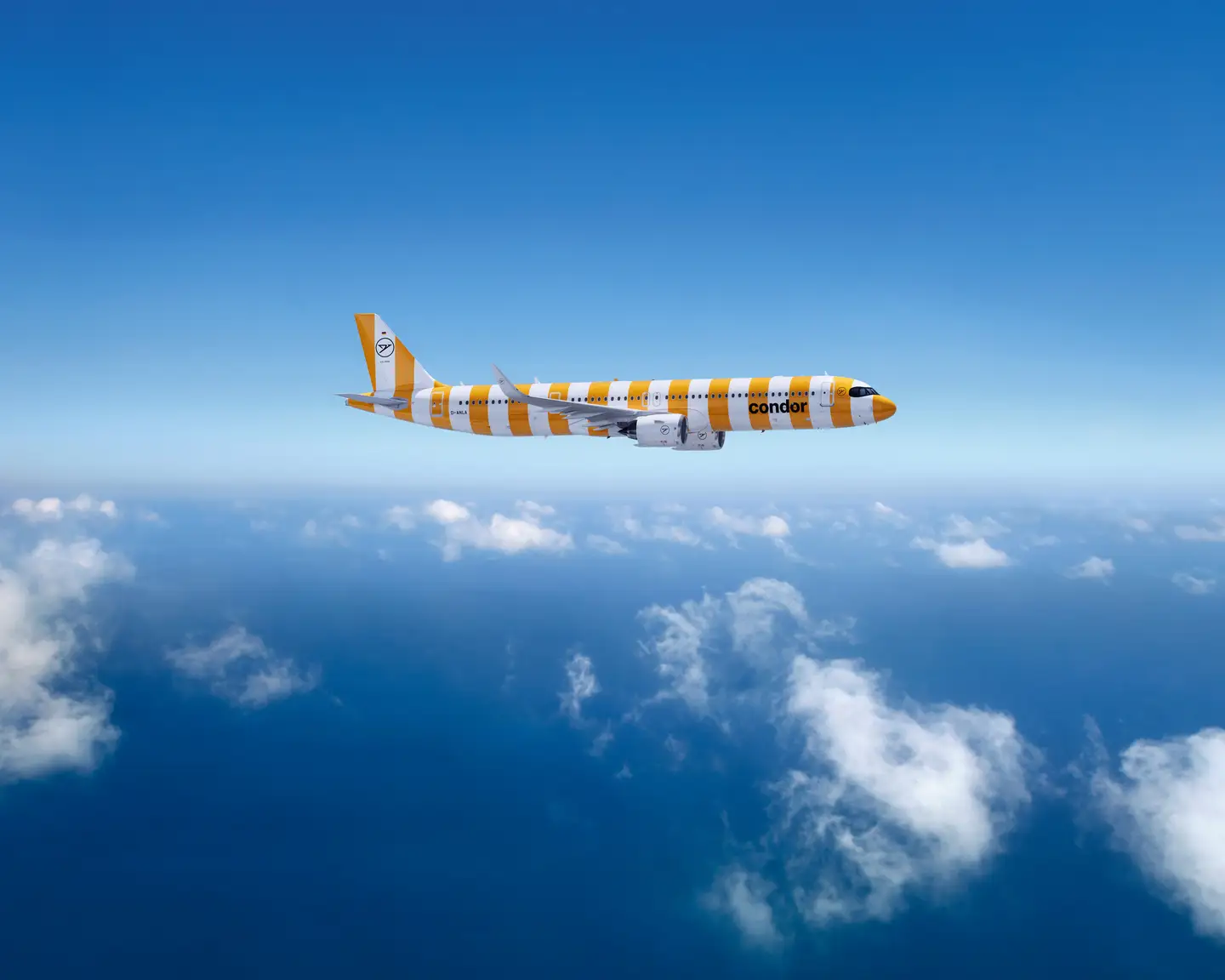 Un Airbus A321neo de Condor de color Sunshine sobre un cielo azul claro, con nubes blancas debajo.