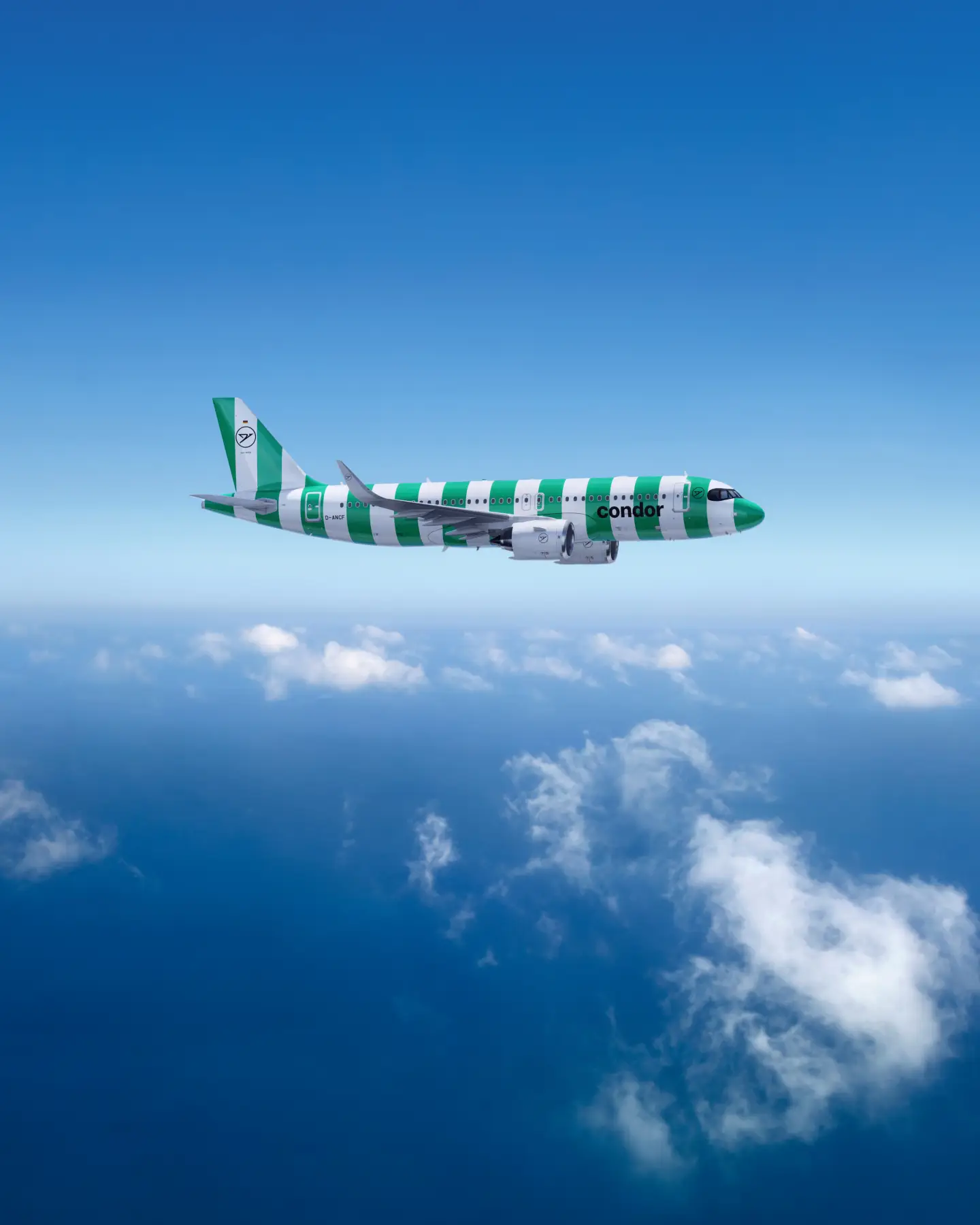Condor Airbus A320neo in een groen gestreepte beschildering boven een heldere hemel