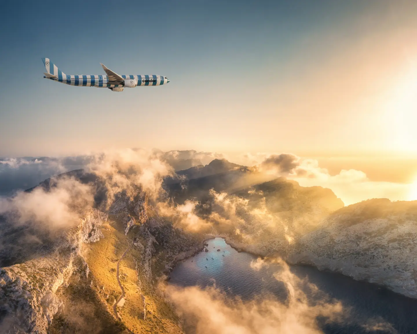 Ein Flugzeug des Typs A330neo überfliegt eine Landschaft mit Bergen und grünen Bäumen, darunter blaues Meer, im Hintergrund Wolken und goldenes Sonnenlicht.