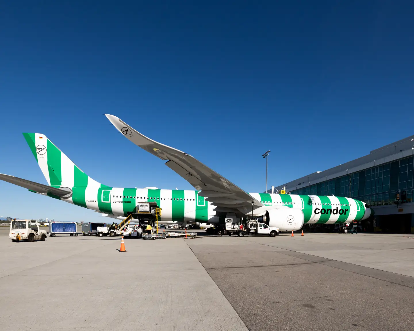 Bij de terminal staat een A330neo in de kleur Island (groen) geparkeerd.