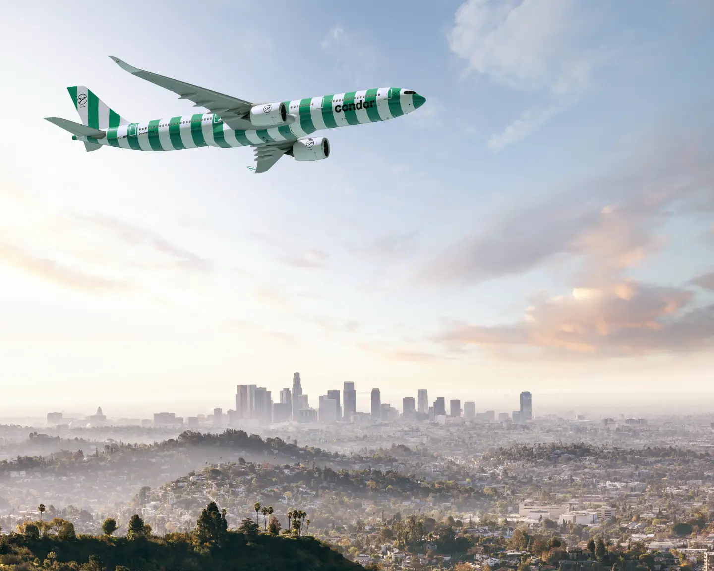 Pohled z ptačí perspektivy na město Los Angeles. V popředí je letadlo Condor A330neo v barvě Island.