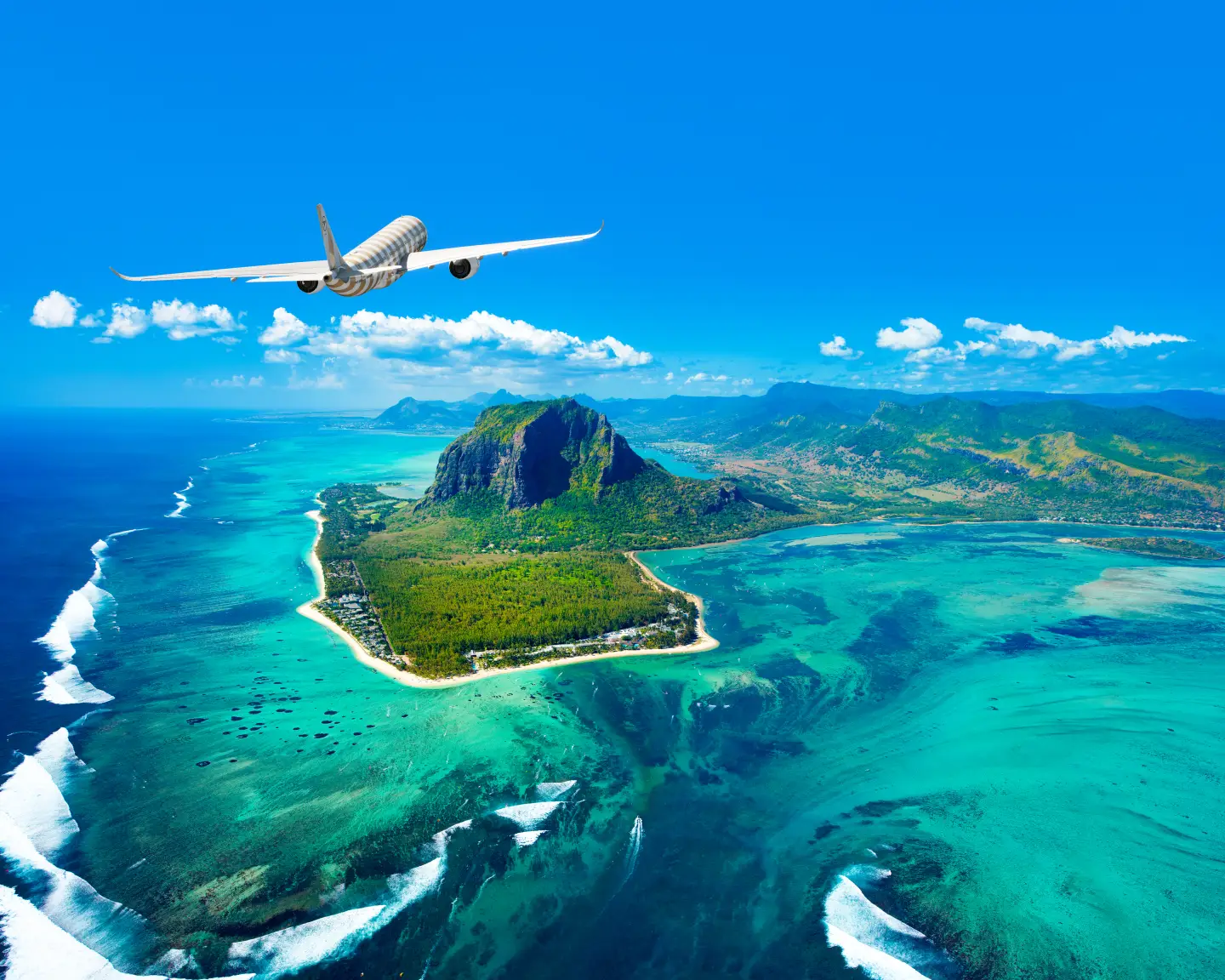 Condor A330 Neo in de lucht boven Mauritius, met een turkooizen zee en een groene kustlijn eronder