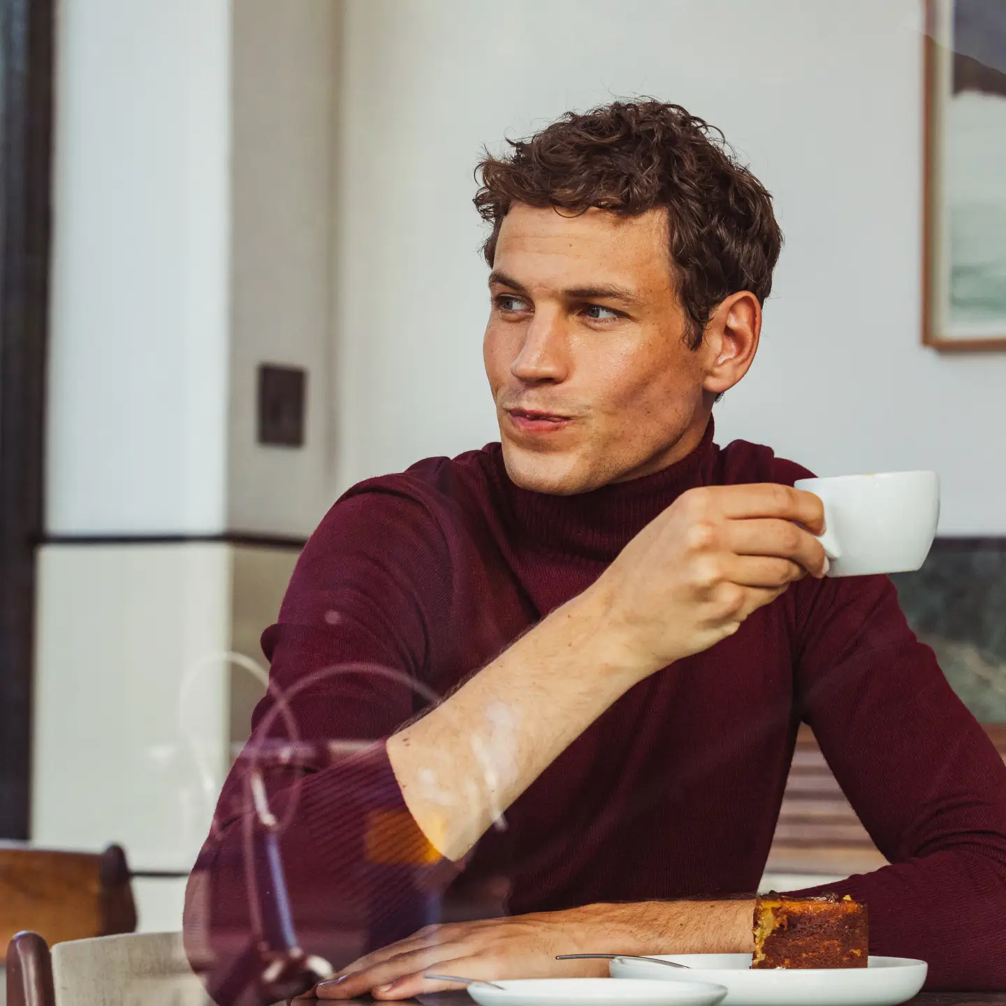 Hombre desayunando una taza de café en un hotel.
