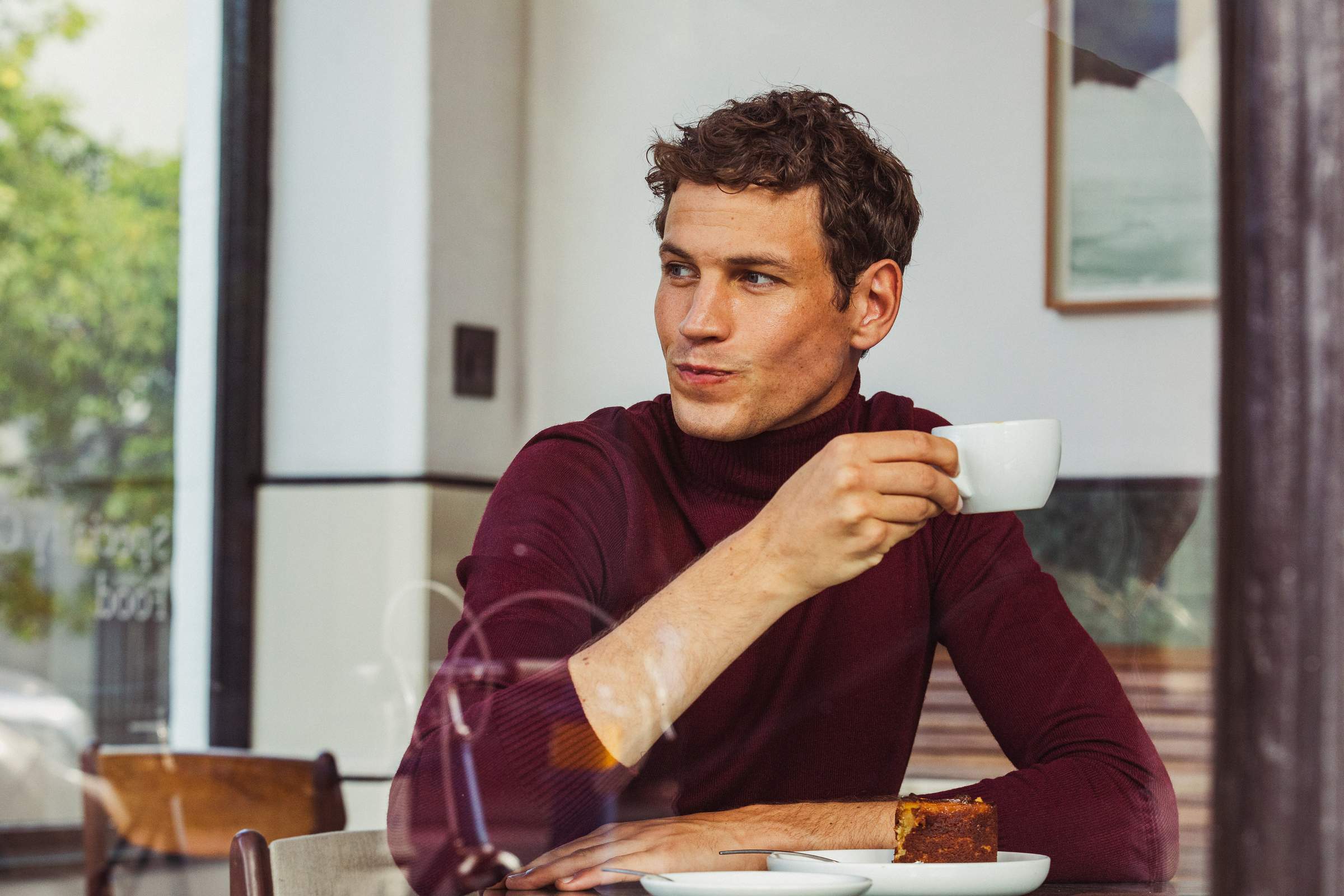 Hombre desayunando con una taza de café en un hotel.