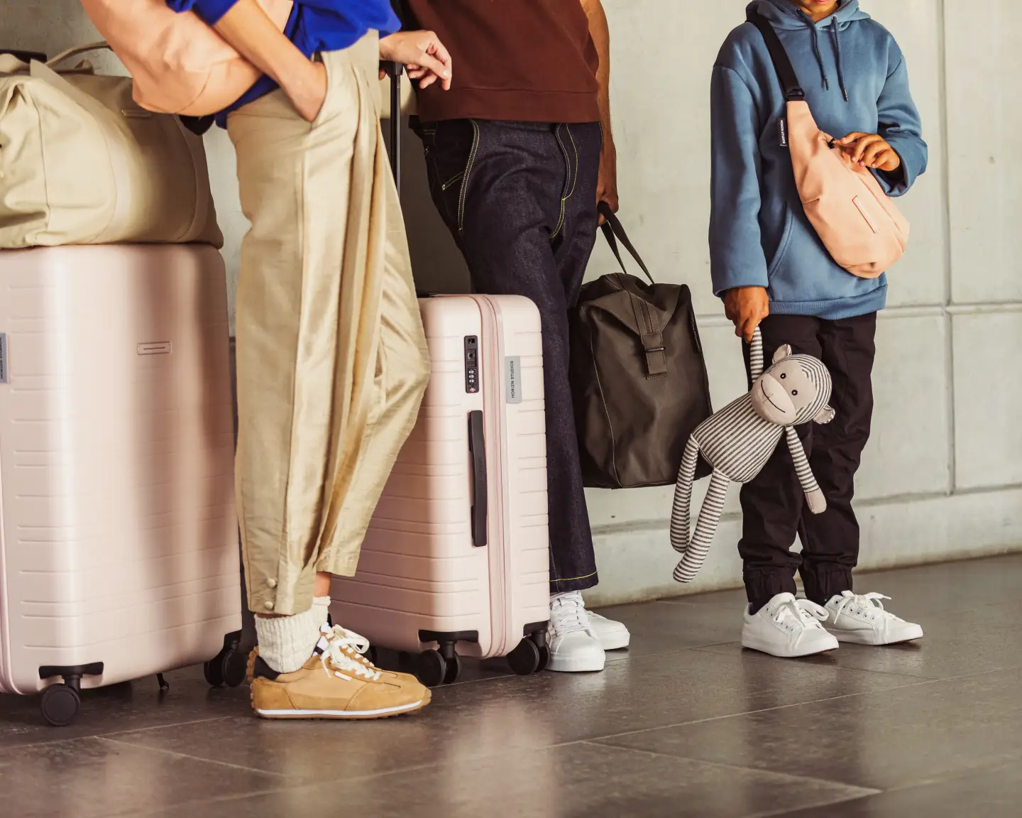 Un groupe de personnes debout avec leurs bagages à l’aéroport.