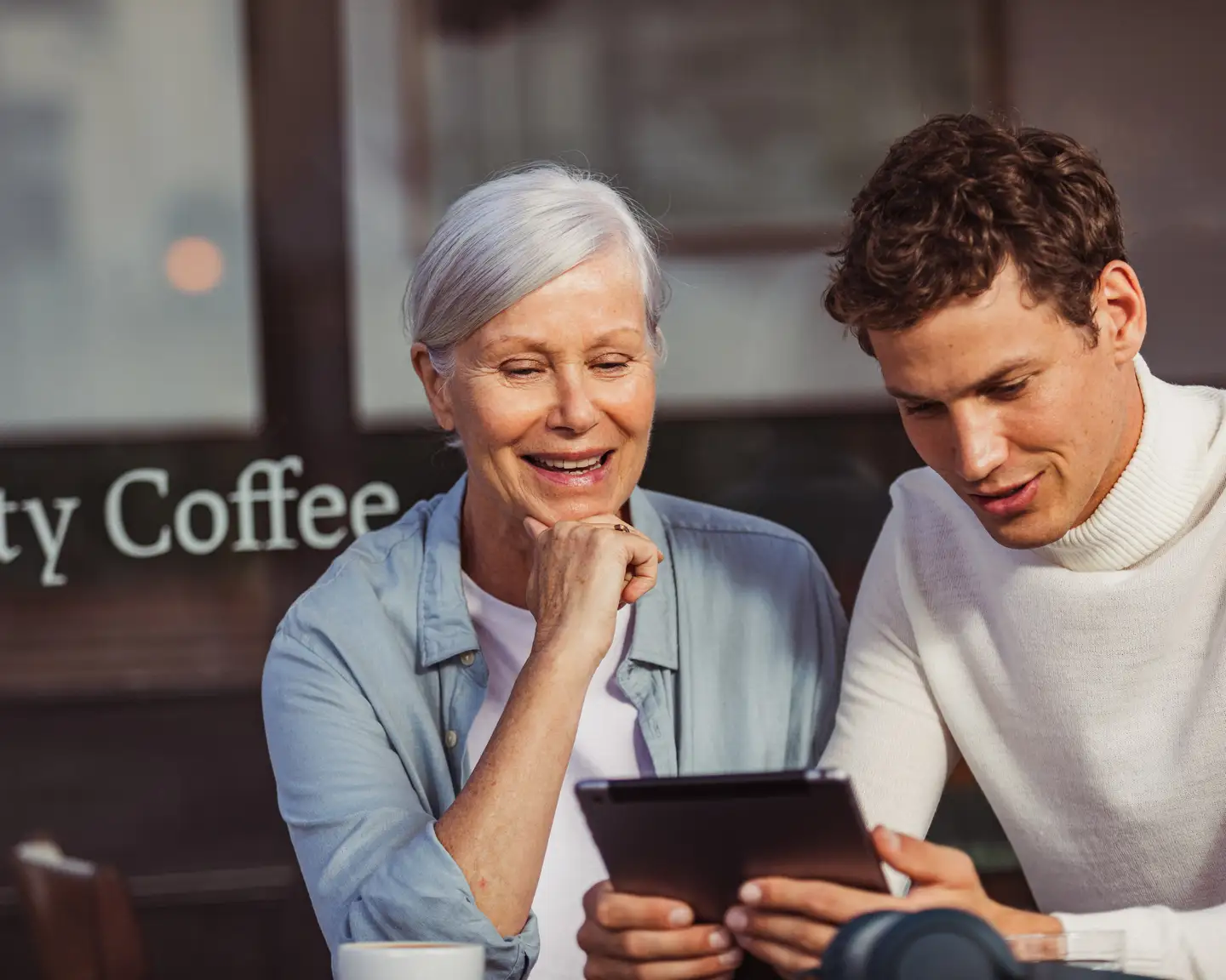 Una mujer y un hombre viendo algo juntos en un iPad.