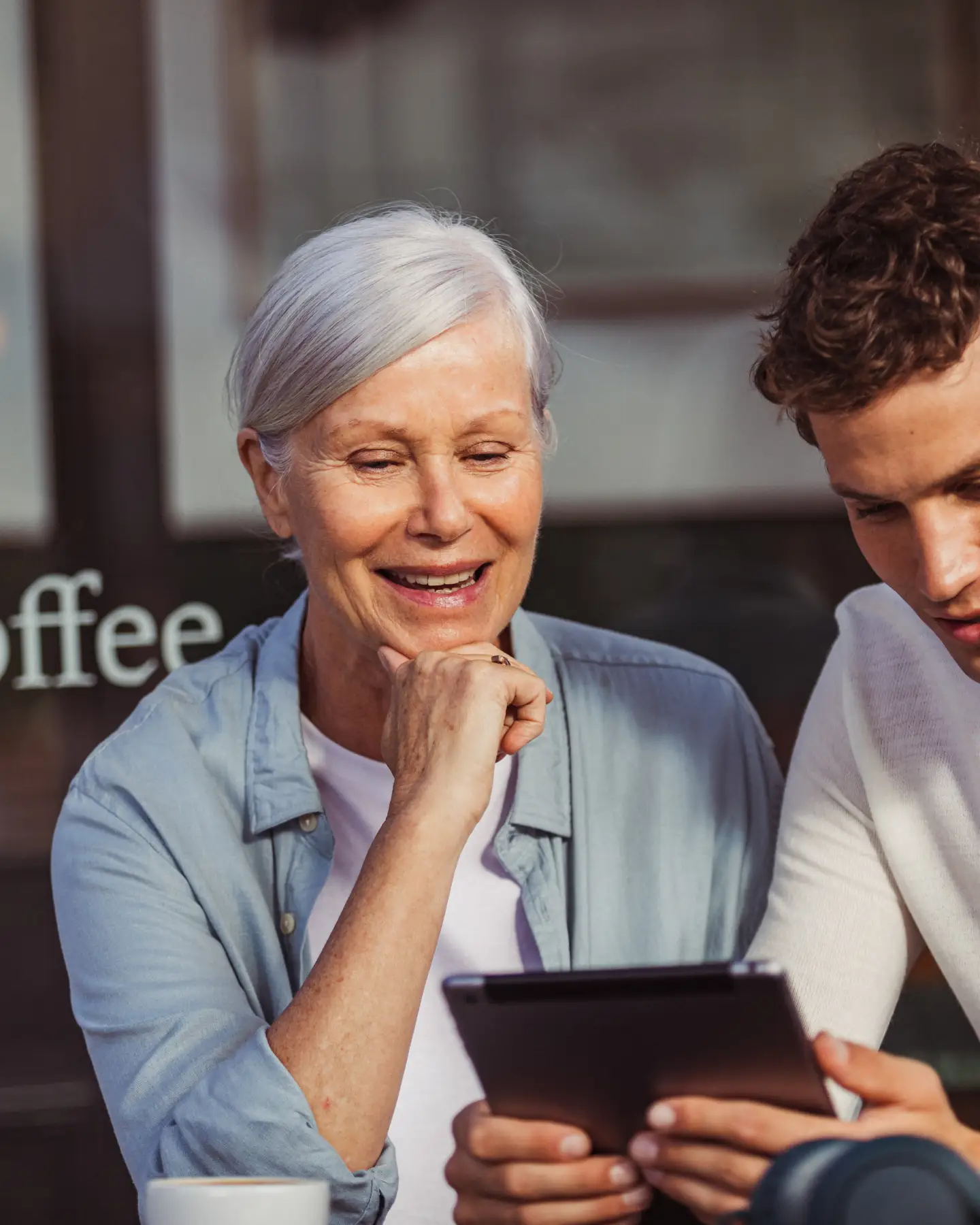 A woman and man watching something on an iPad together.
