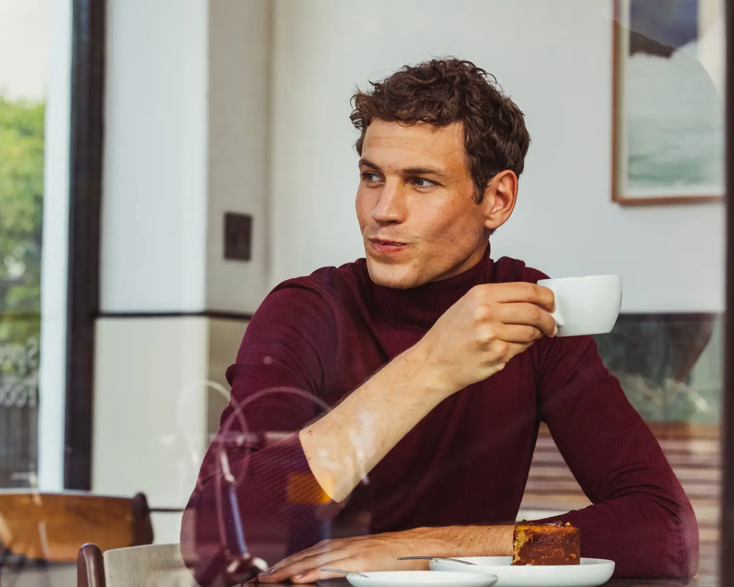 Een man die een kop koffie drinkt tijdens het ontbijt in een hotel.