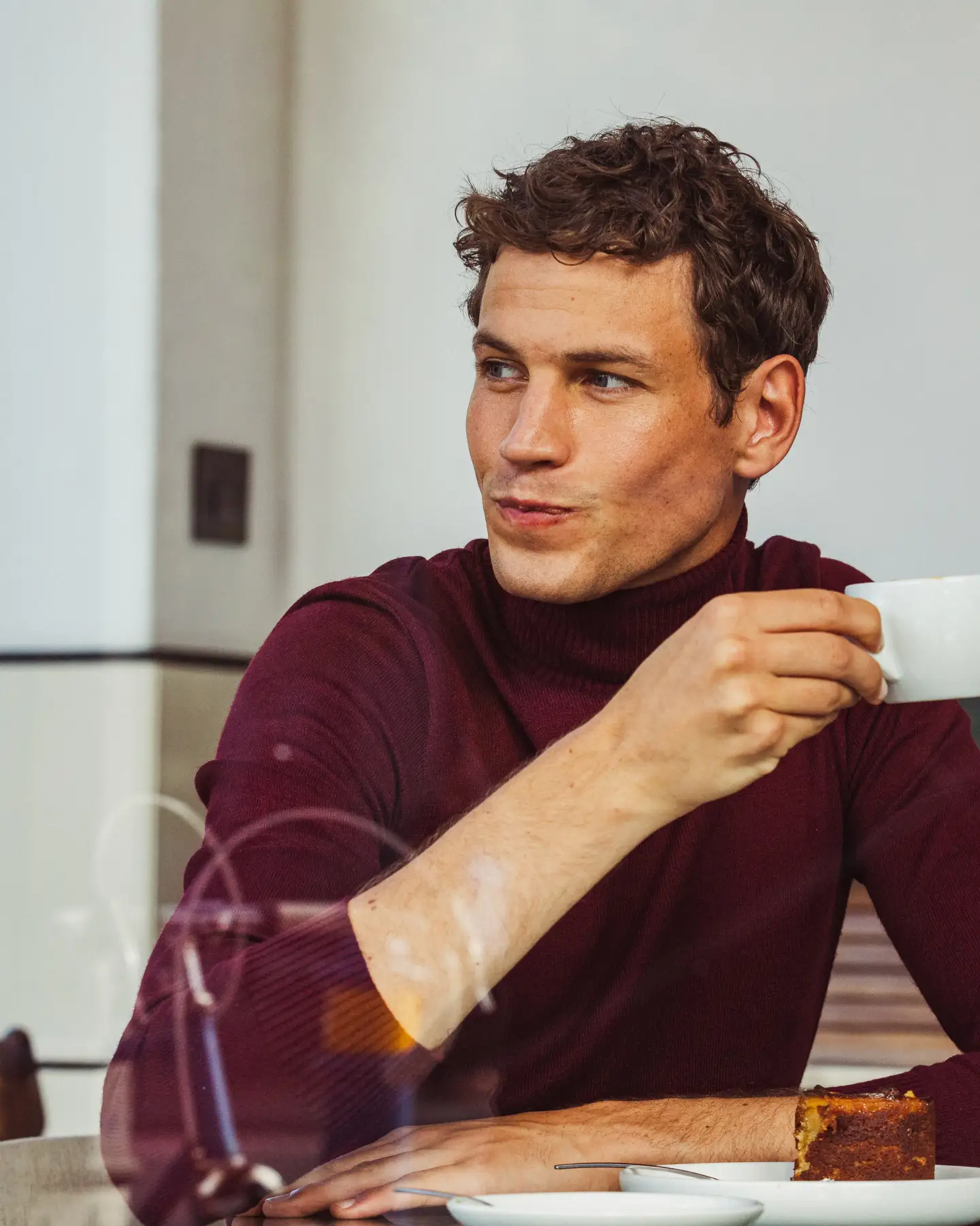 Een man die een kop koffie drinkt tijdens het ontbijt in een hotel.