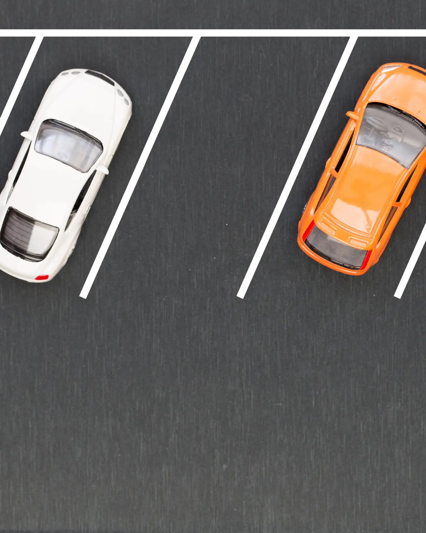 Four cars parked in a car park, photographed from a bird's eye view