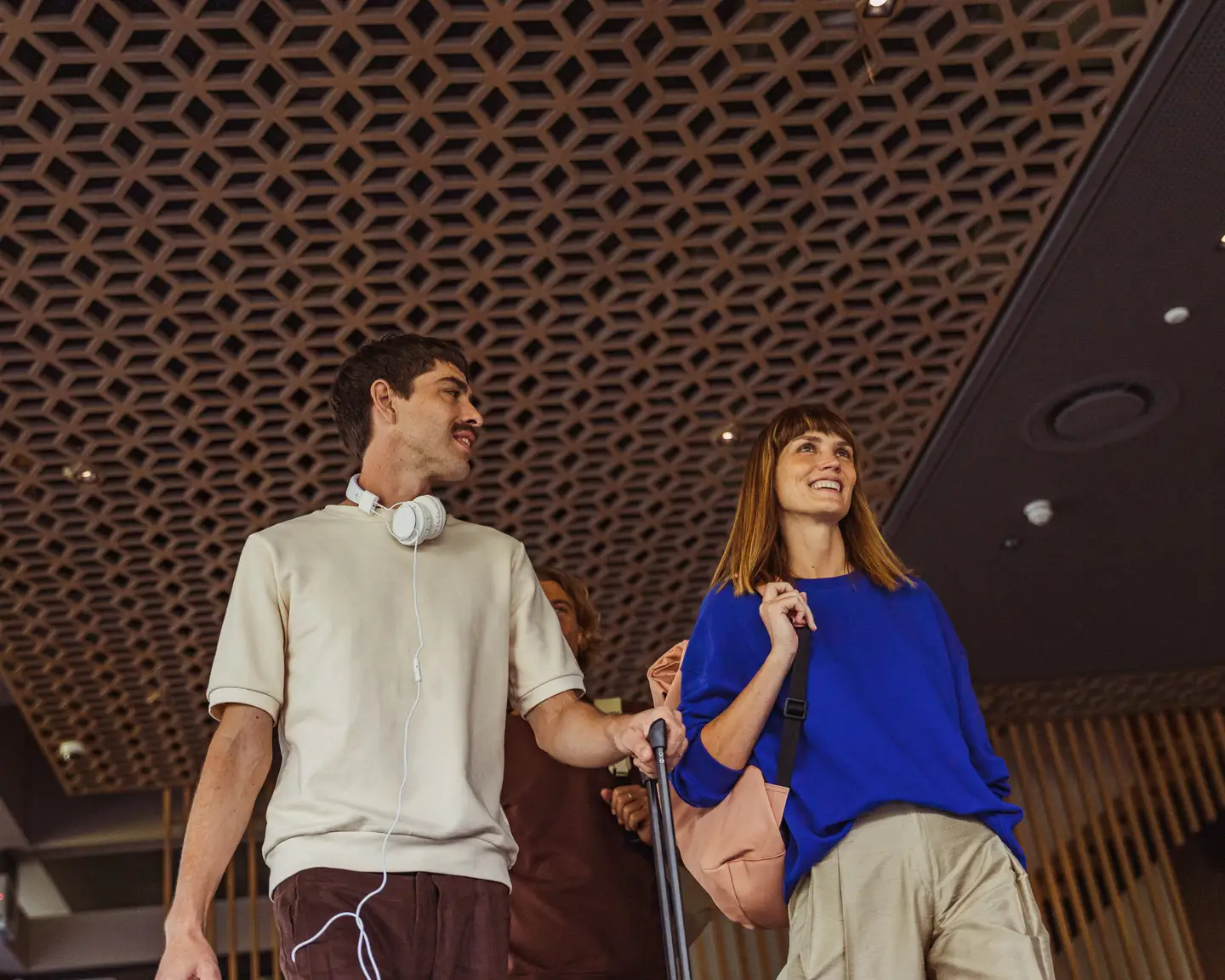 Dos personas caminan por el aeropuerto con sus maletas.