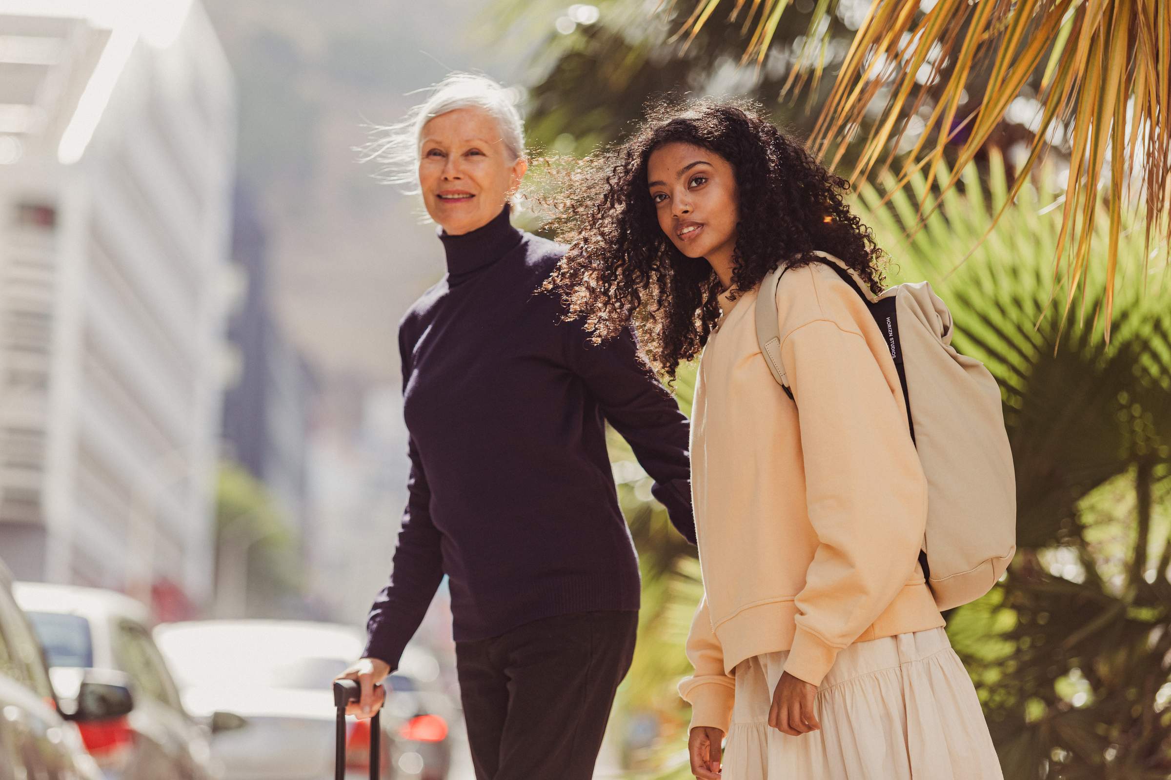 Dos mujeres cruzando la calle con sus maletas.