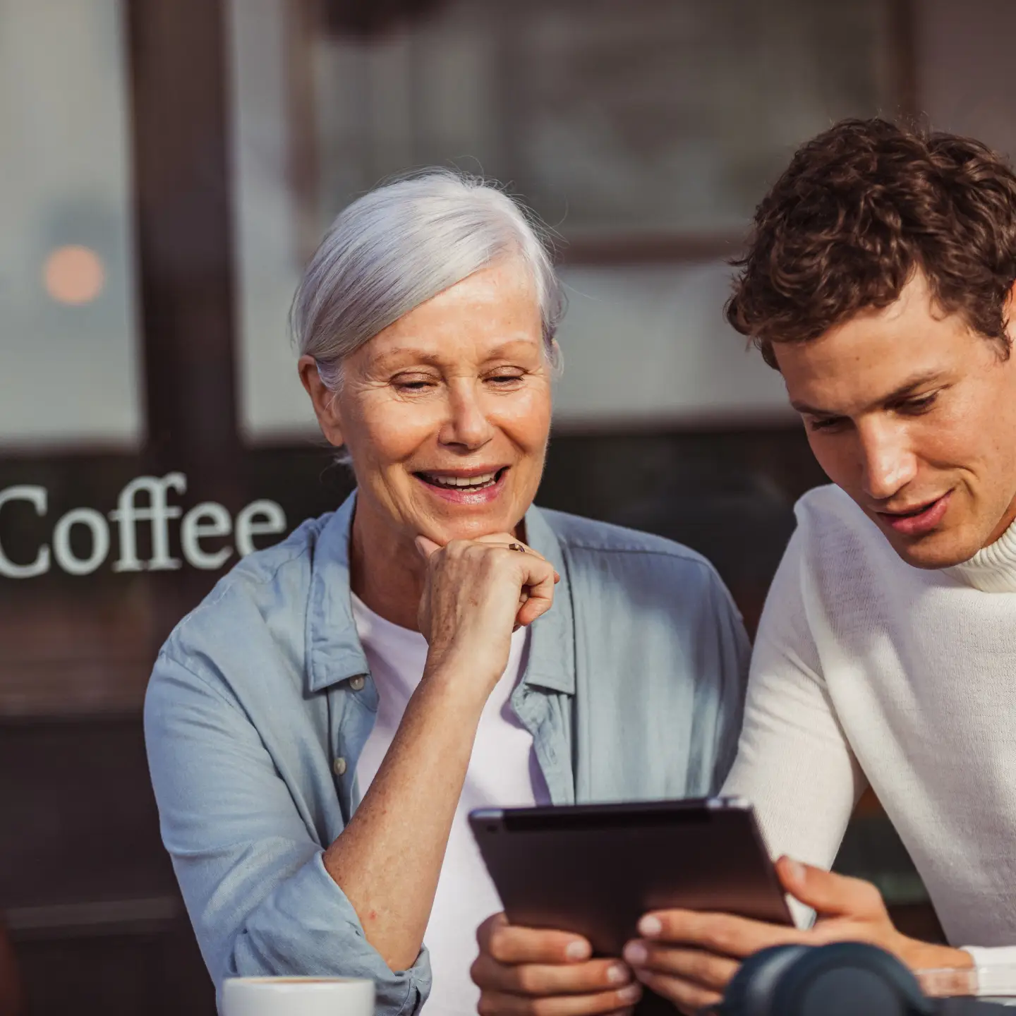 Une femme et un homme regardent quelque chose ensemble sur un iPad.