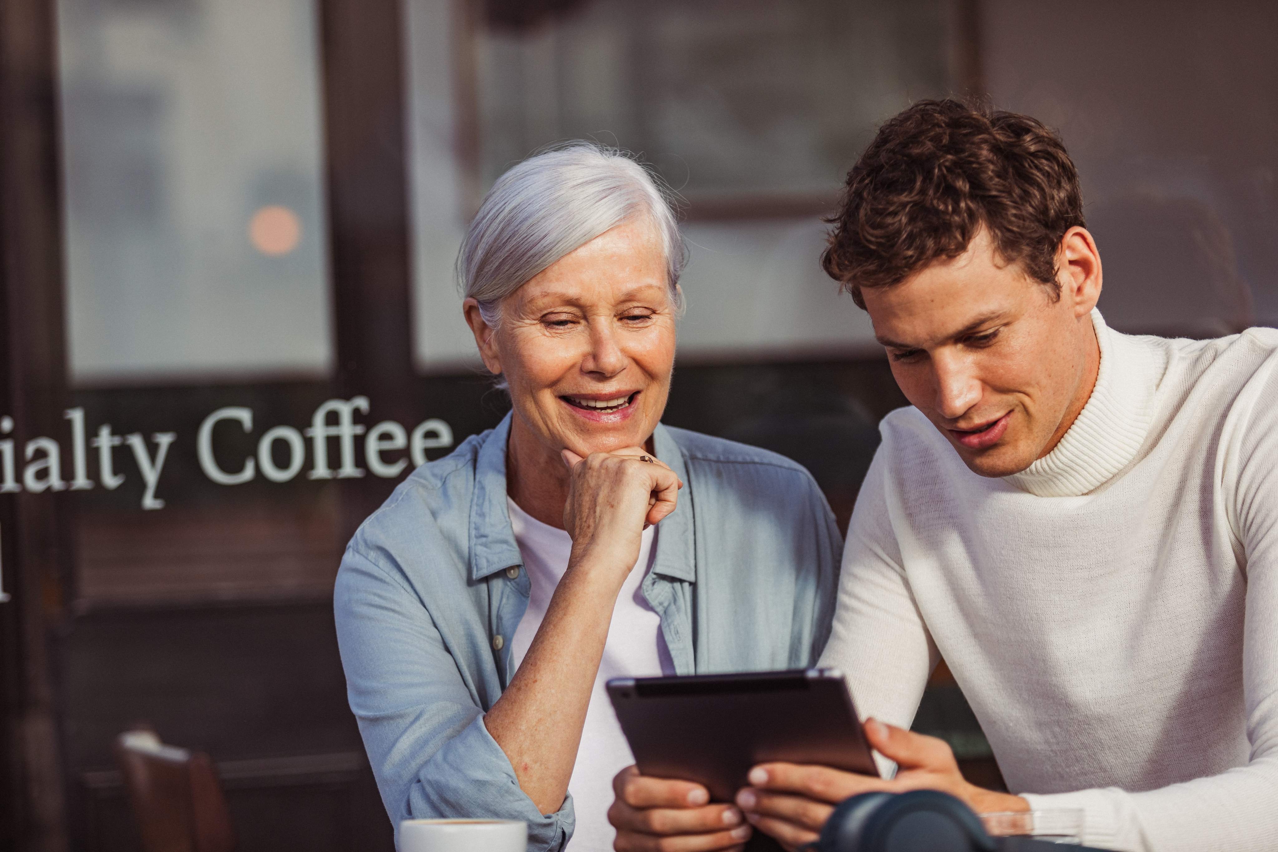 Une femme et un homme regardent quelque chose ensemble sur un iPad.