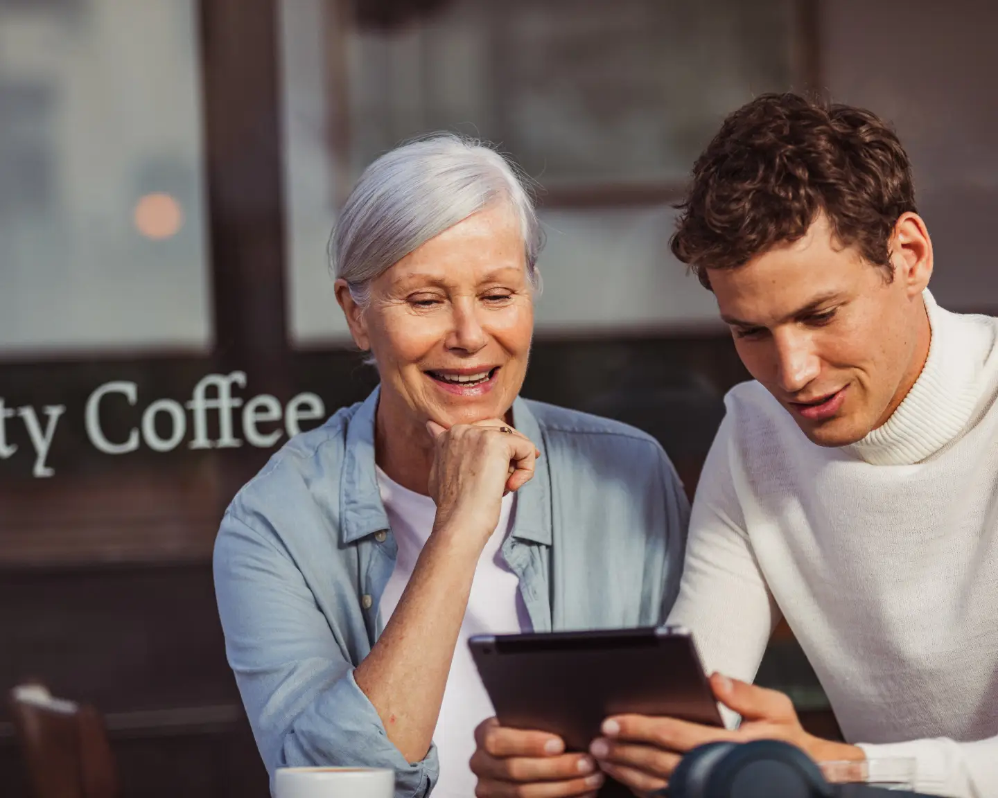 Une femme et un homme regardent quelque chose ensemble sur un iPad.