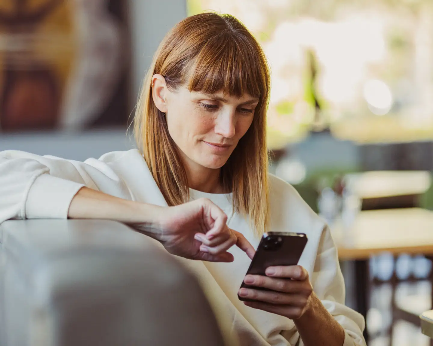 Una mujer con un teléfono inteligente en la mano.