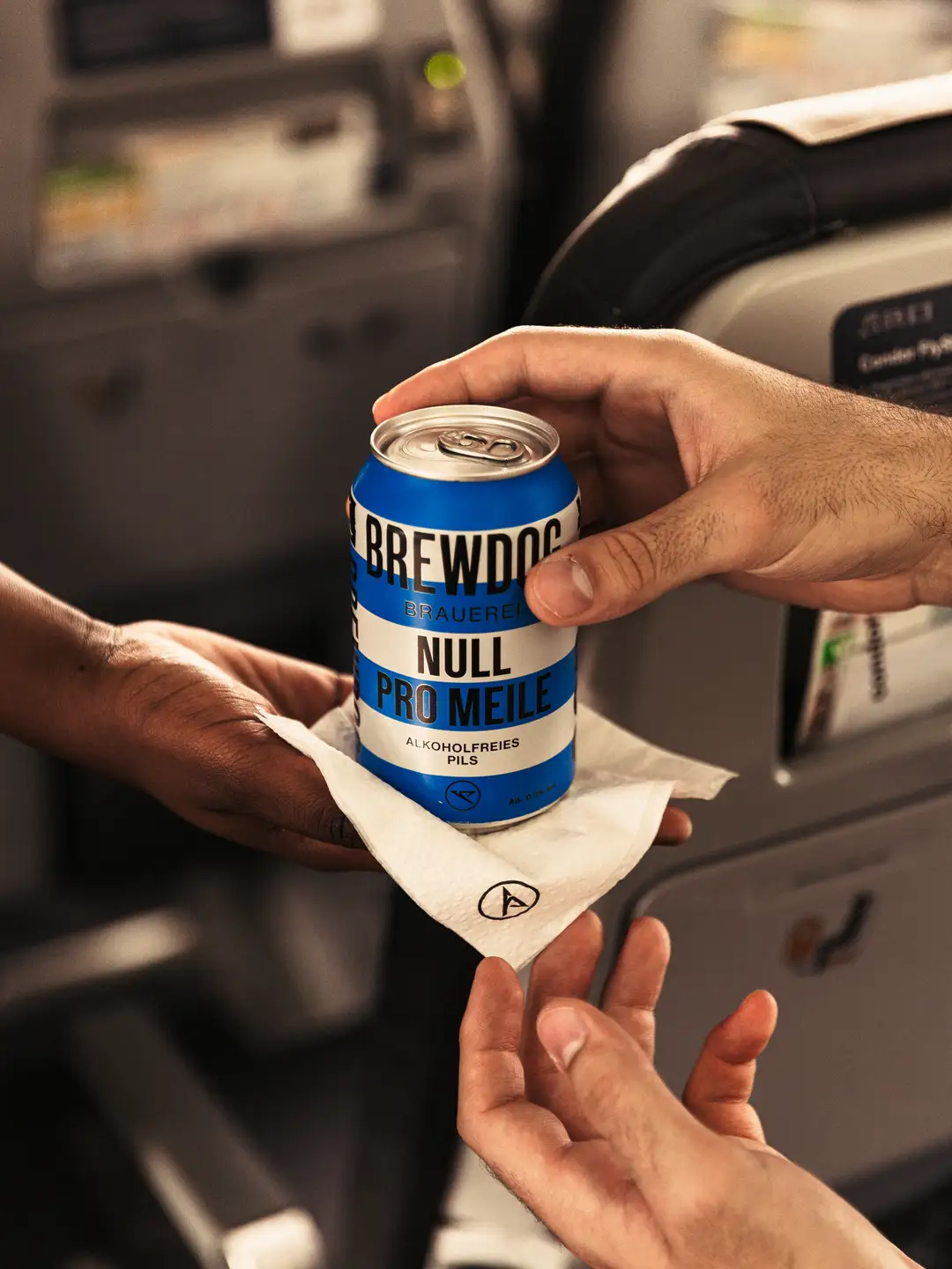 Una lata de cerveza con rayas azules se sirve sobre una servilleta