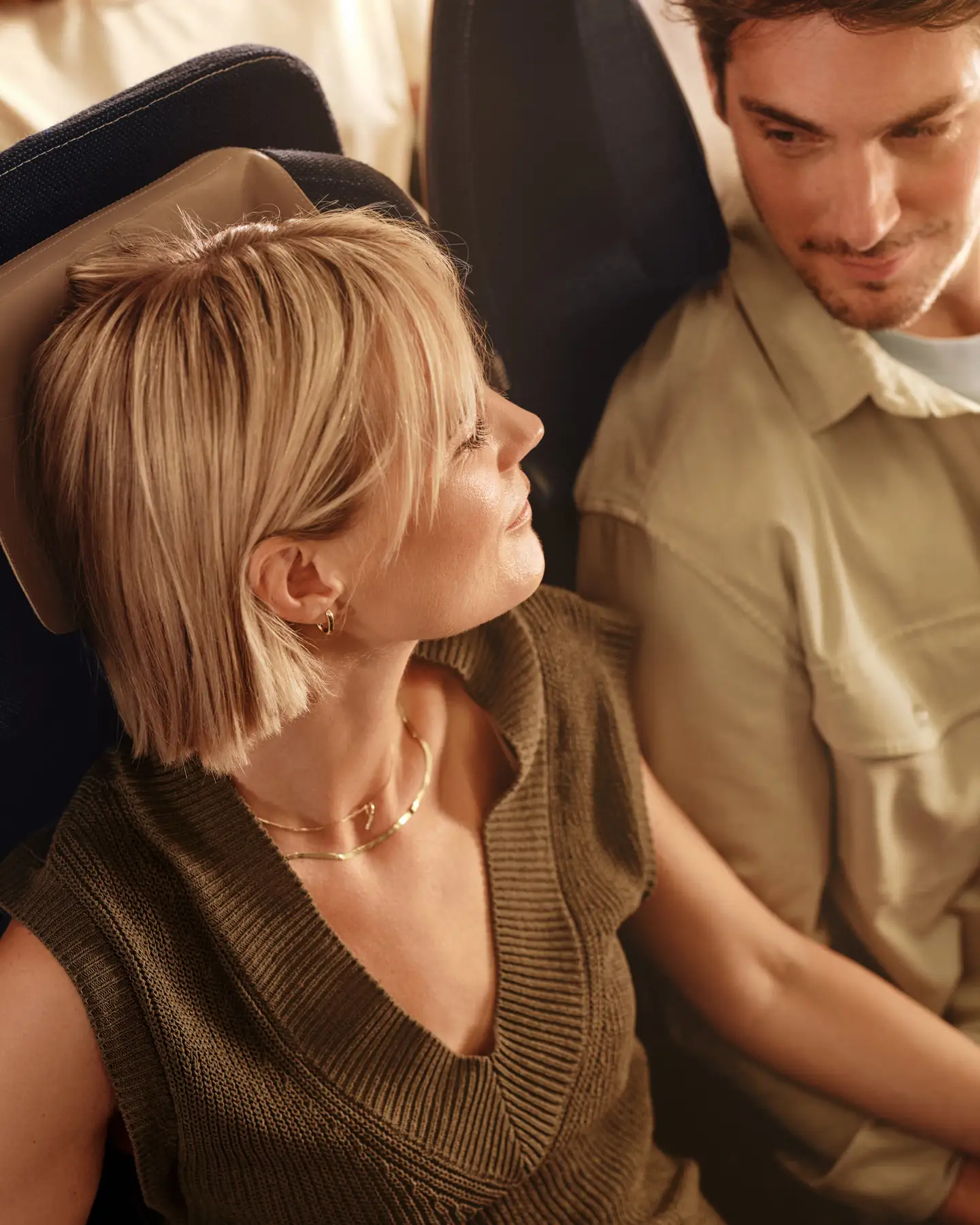 Un hombre y una mujer se sientan en la Economy Class a bordo de un avión de Condor.