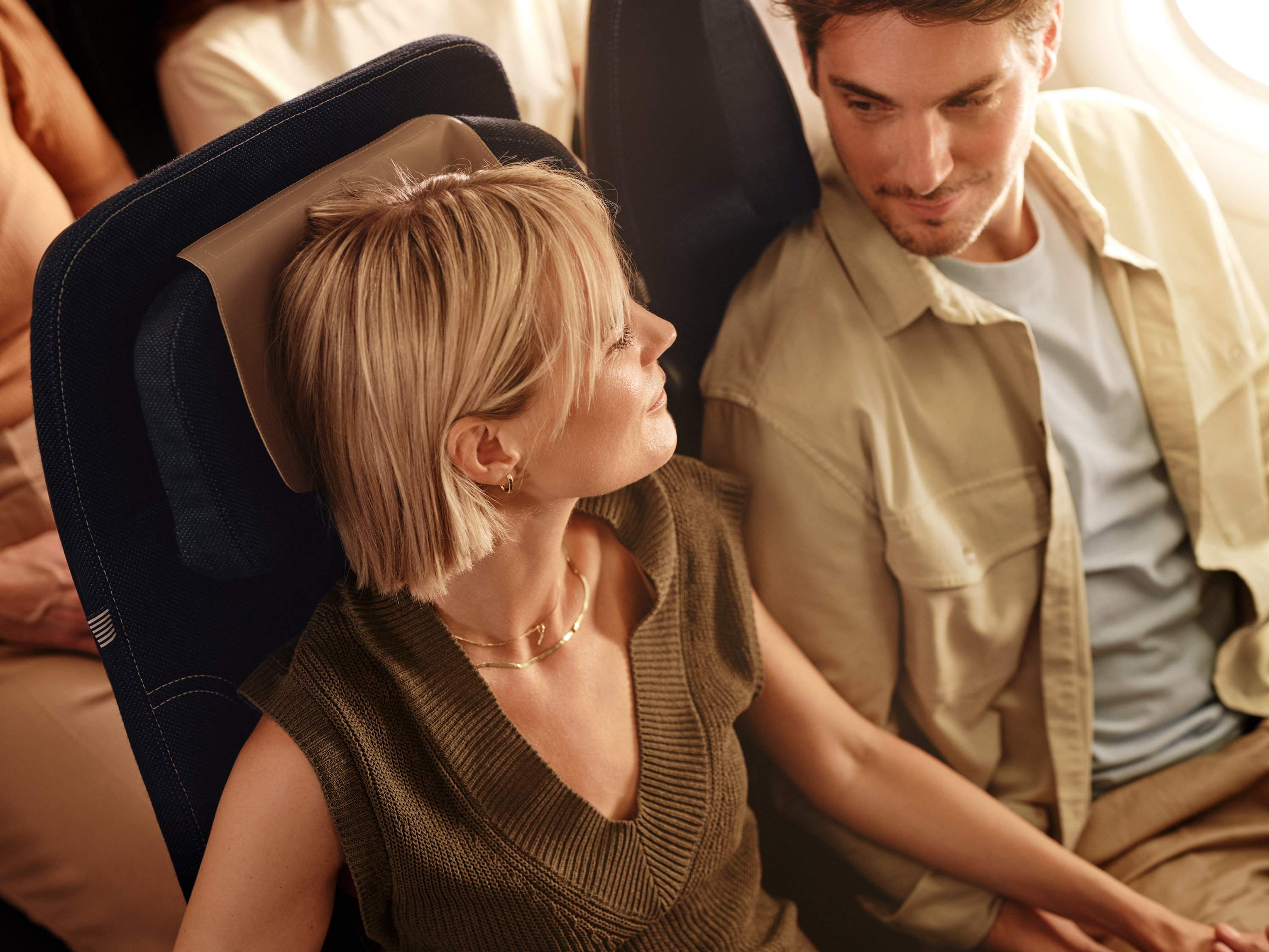 Un hombre y una mujer se sientan en la Economy Class a bordo de un avión de Condor.