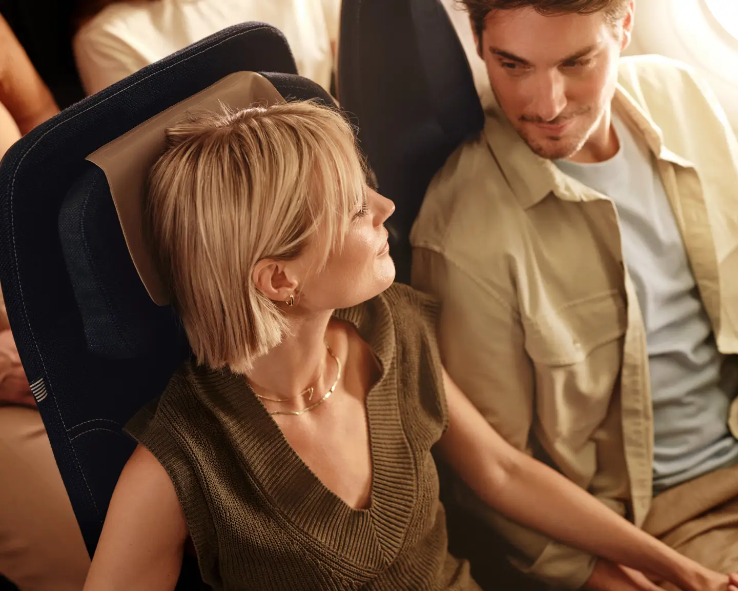 Muž a žena sedí v Economy Class na palubě letadla Condor.