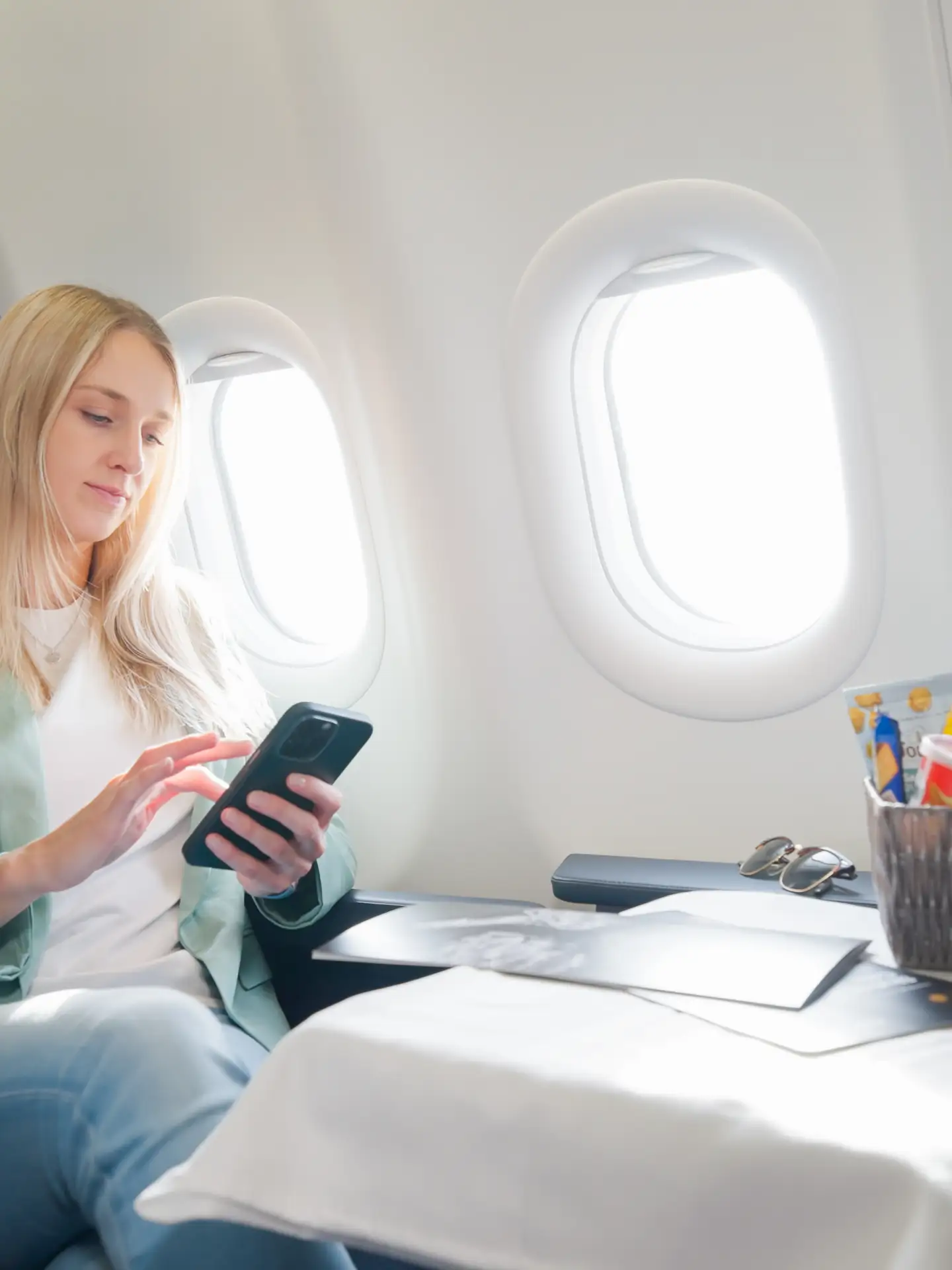 Una mujer está usando su teléfono inteligente a bordo.