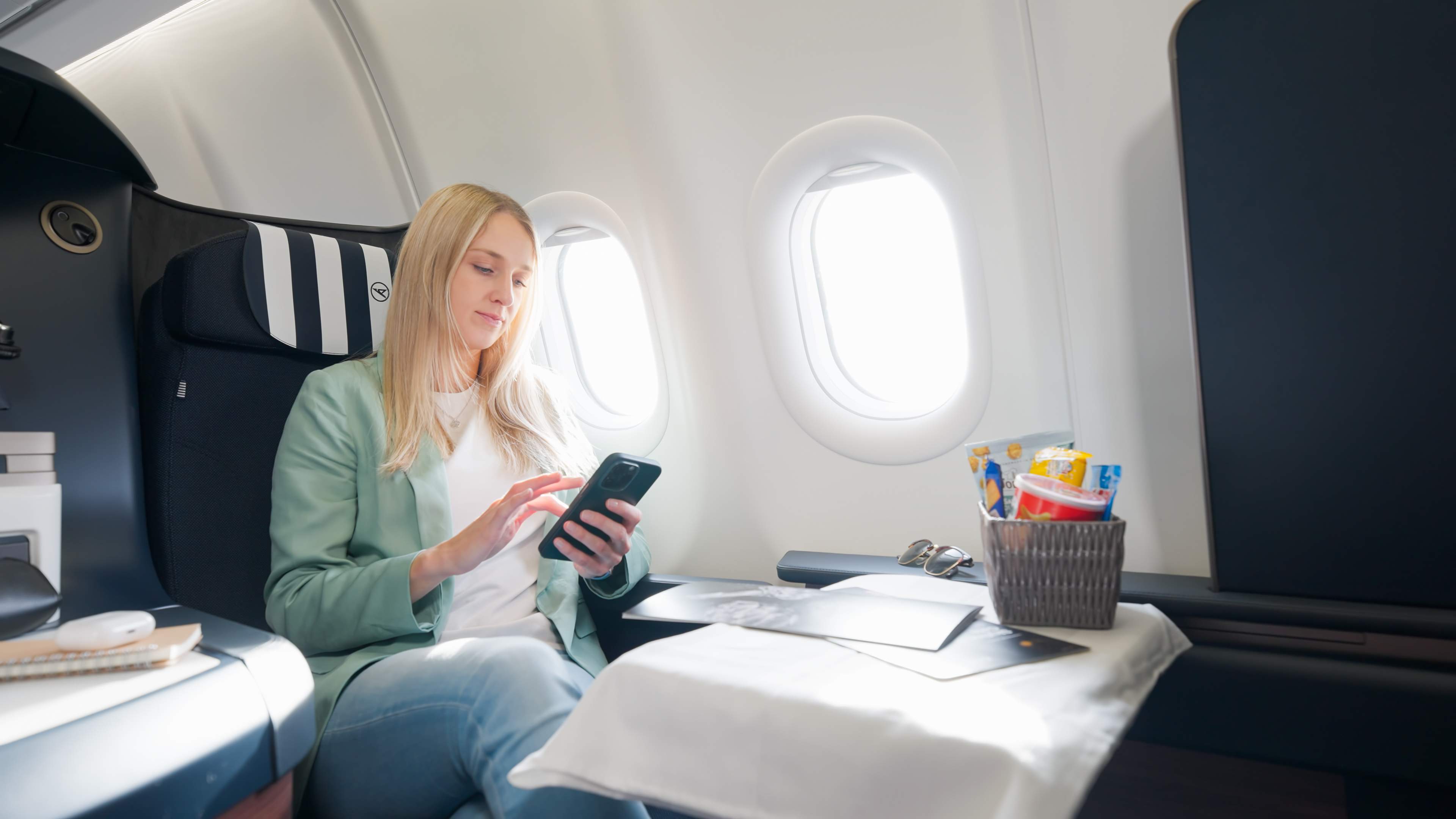 Een vrouw gebruikt haar smartphone aan boord.