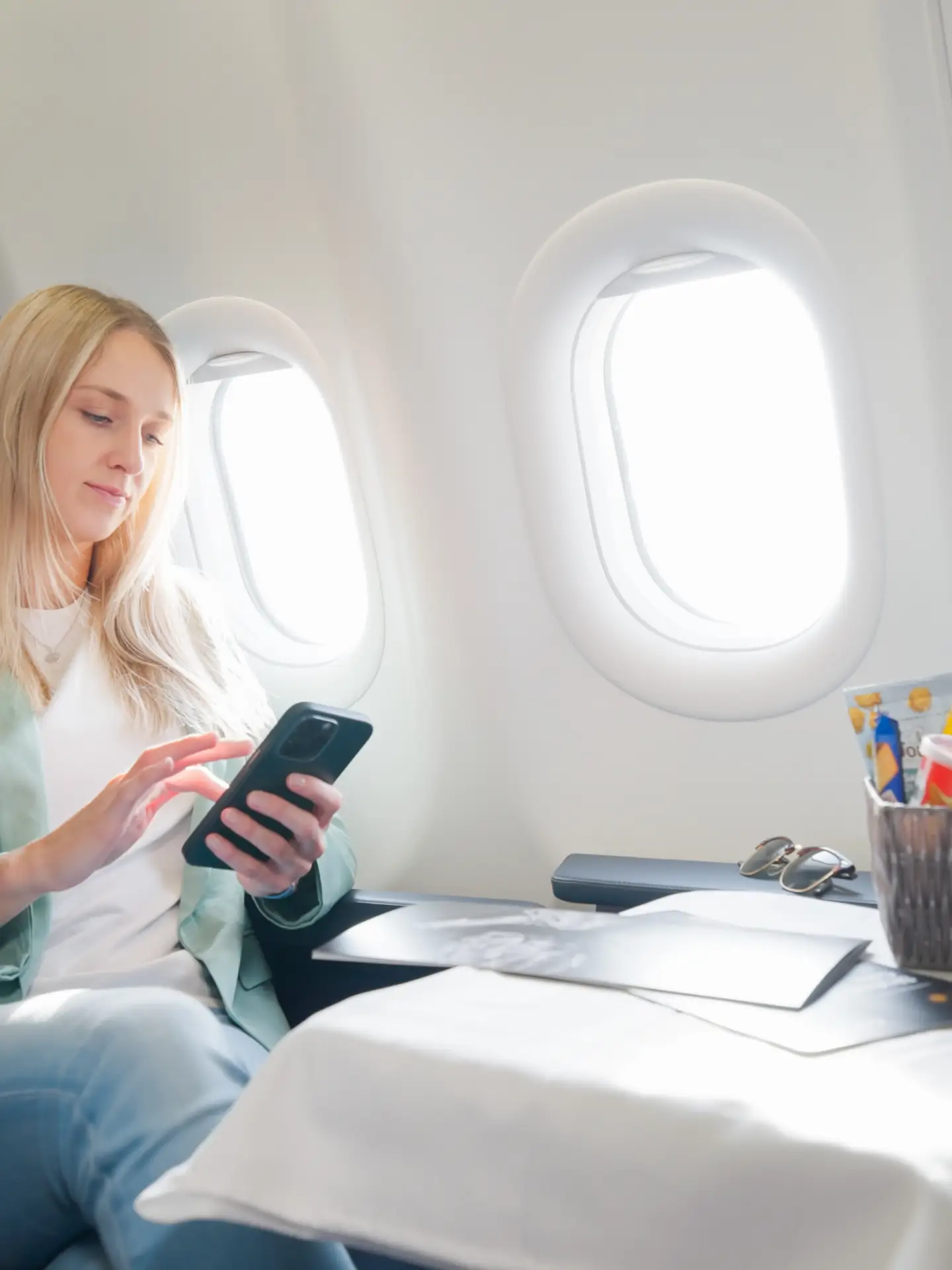 Een vrouw gebruikt haar smartphone aan boord.