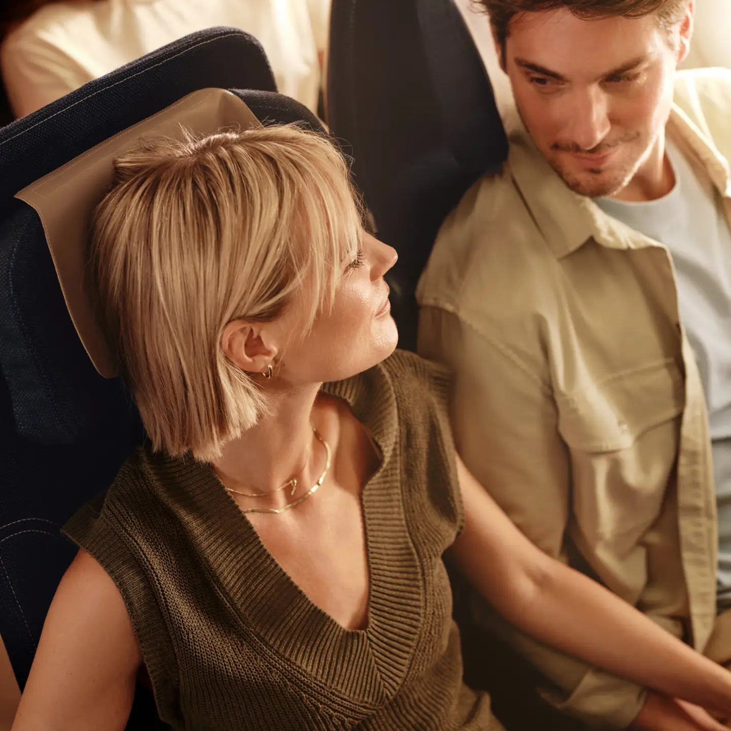 Een man en een vrouw zitten in economy class aan boord van een Condor-vliegtuig