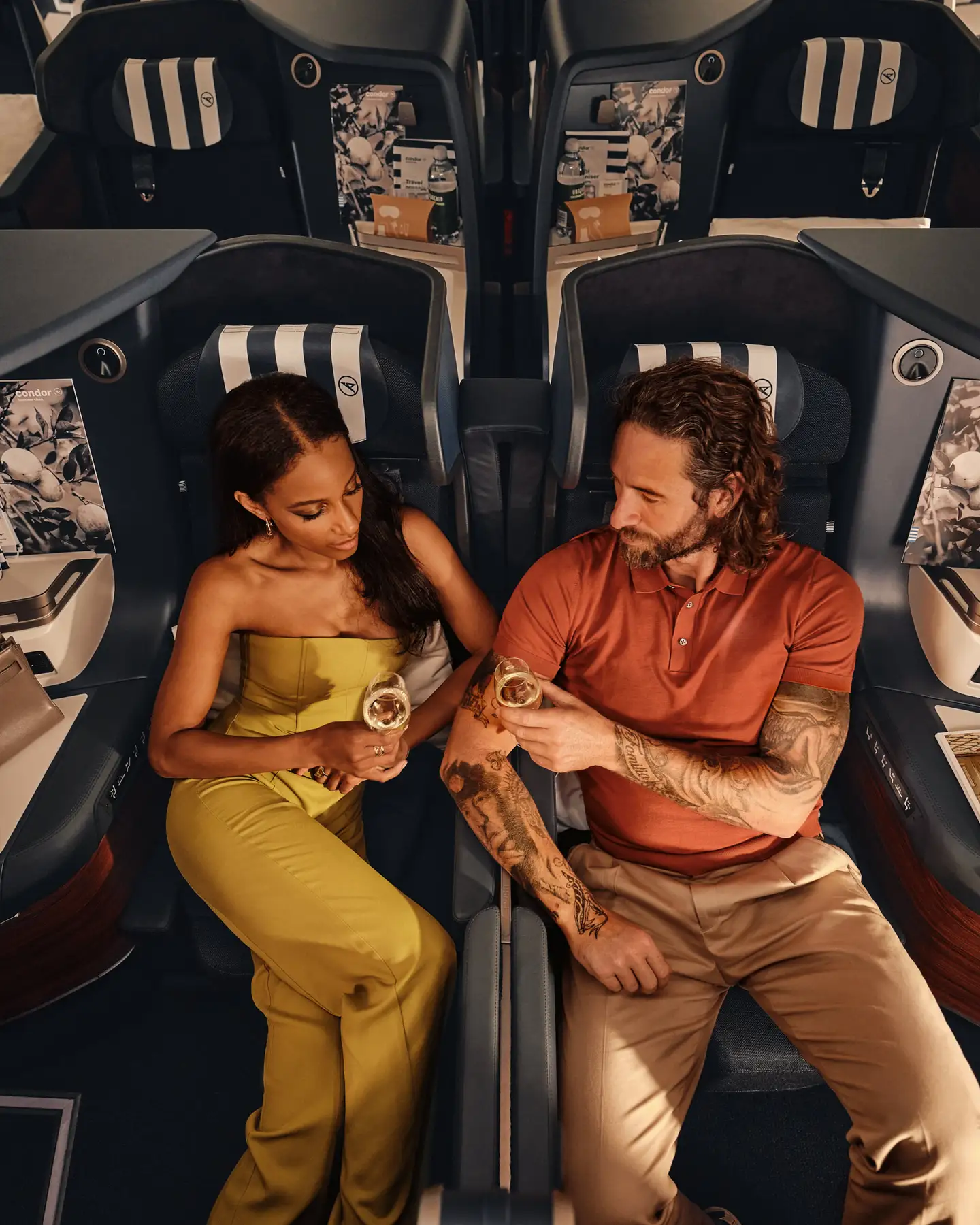 En el Airbus A330neo, una pareja está sentada en asientos Prime Seat de Business Class, bebiendo champán.