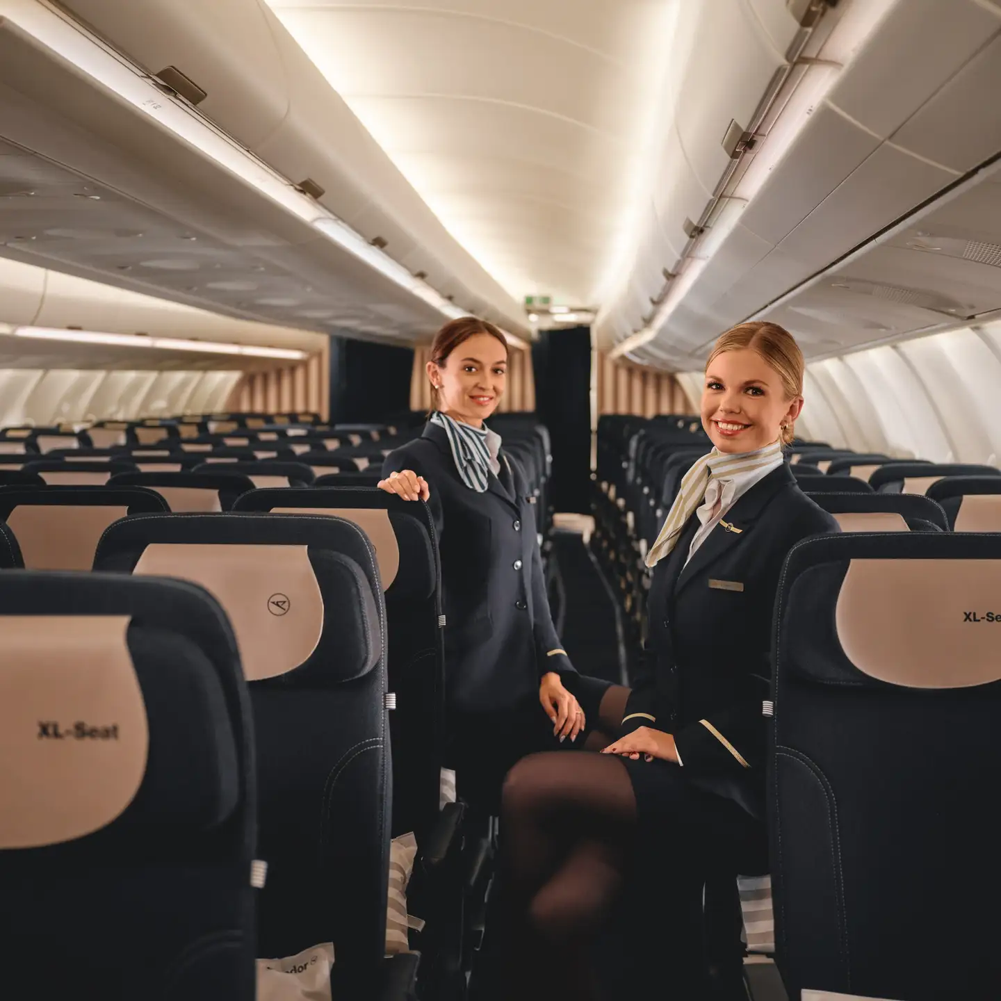 Dos auxiliares de vuelo presentan la comodidad de los asientos en Economy Class