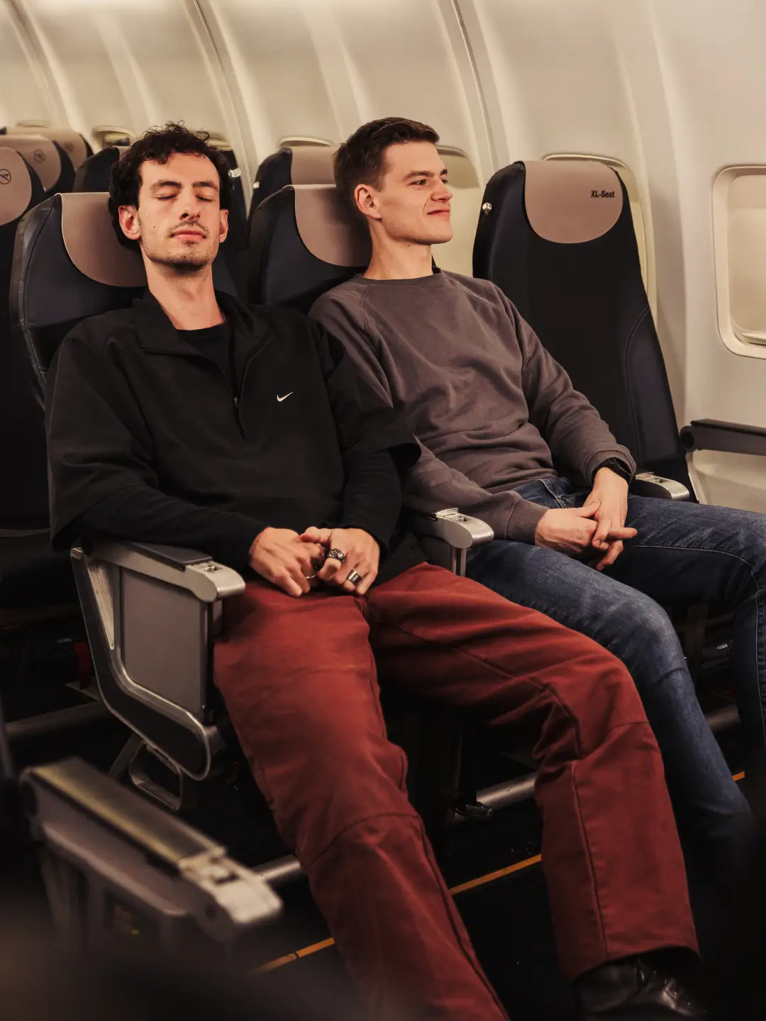 Twee mannen zitten naast elkaar op XL Seats.