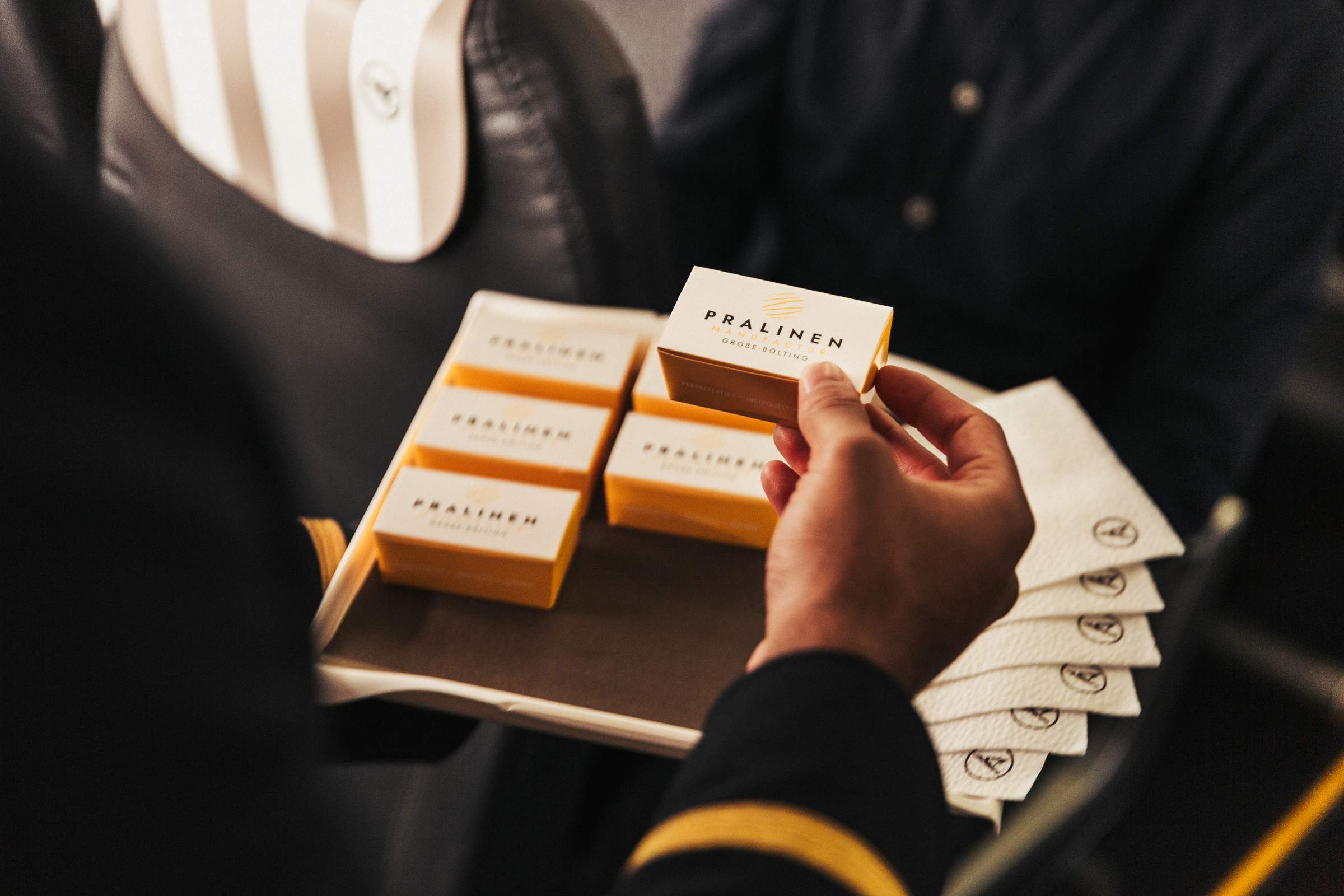 Un pasajero lleva cajas de bombones en las manos