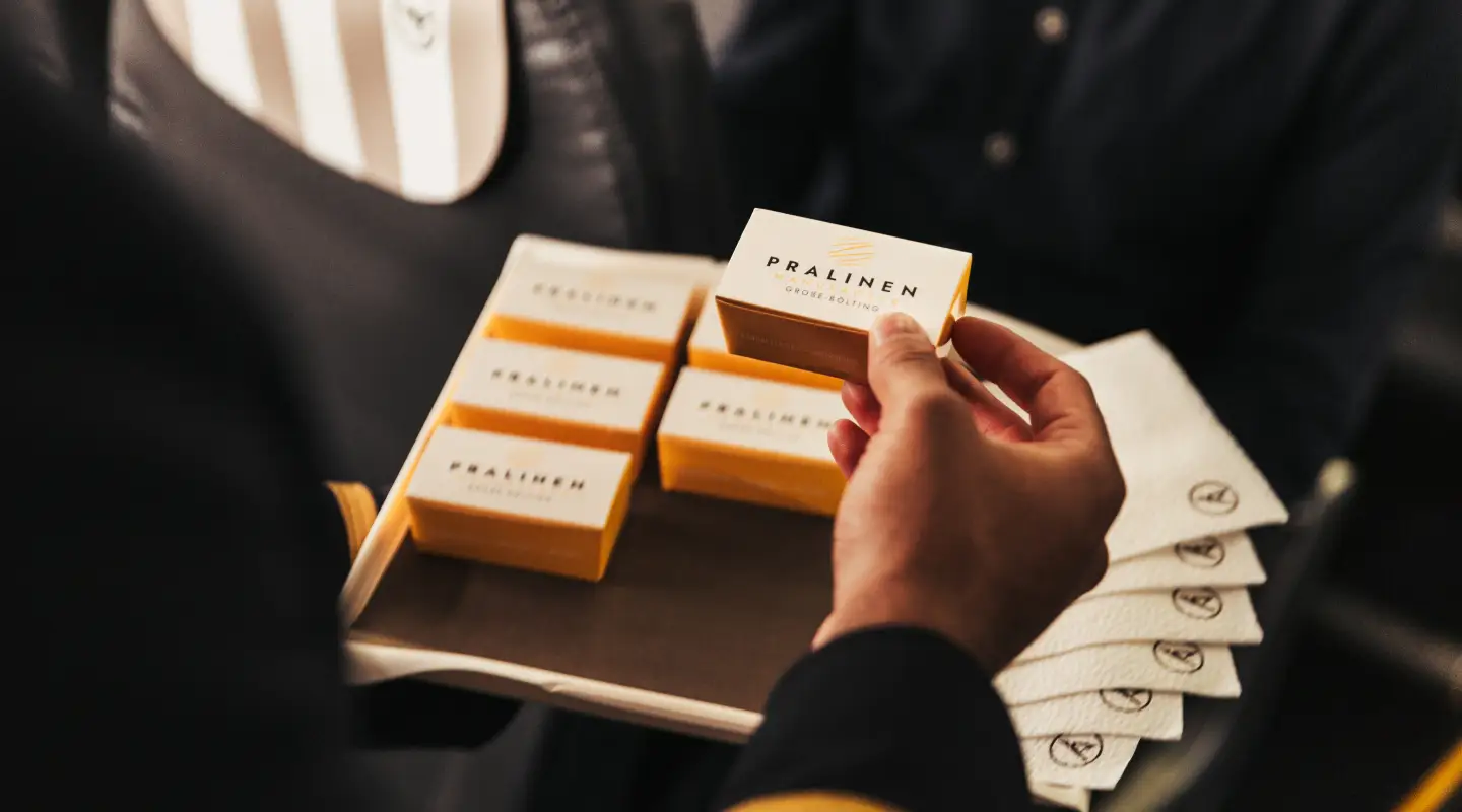 Een passagier houdt dozen chocolaatjes in zijn/haar handen