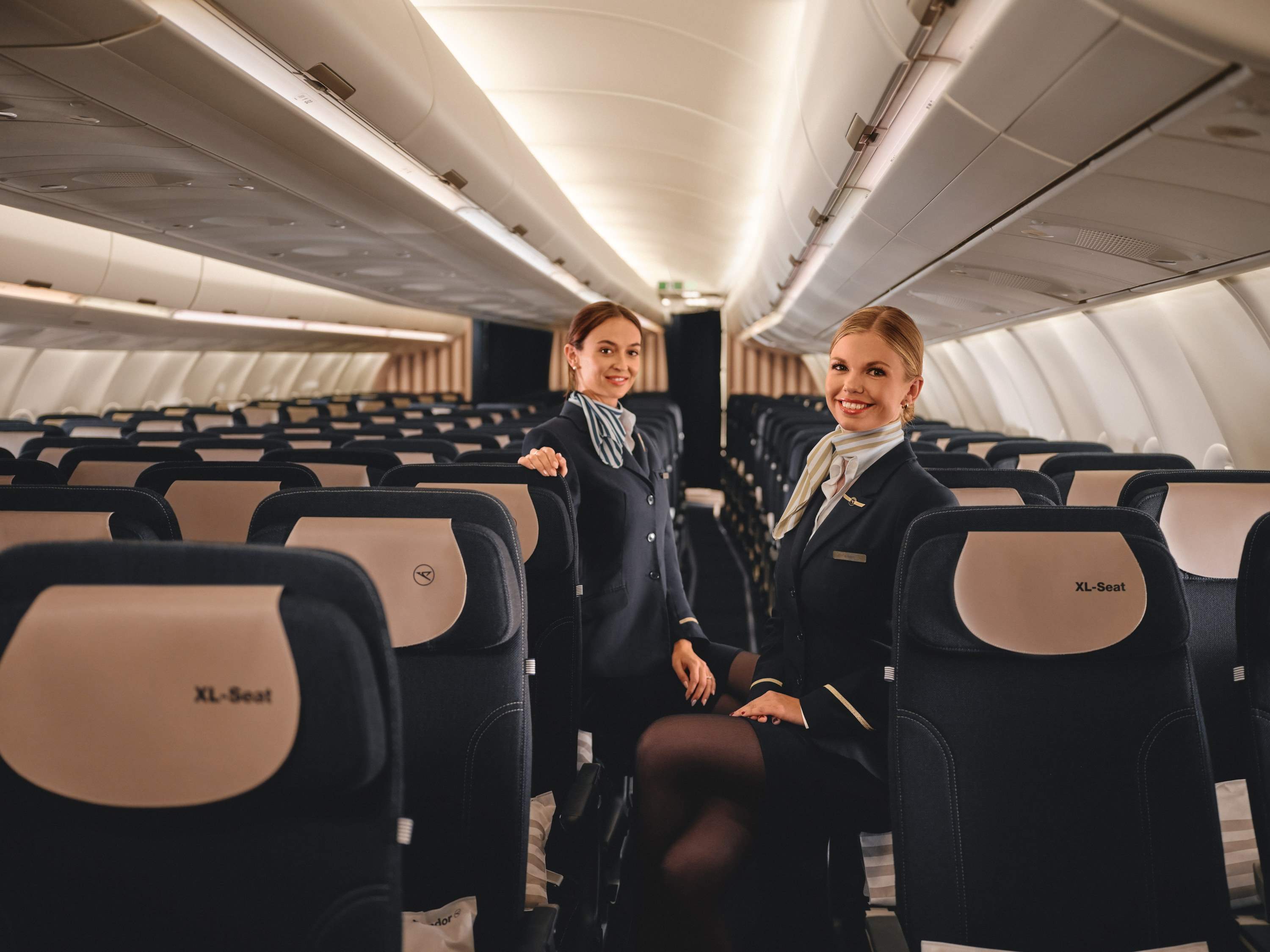 Dos auxiliares de vuelo presentan la comodidad de los asientos en Economy Class