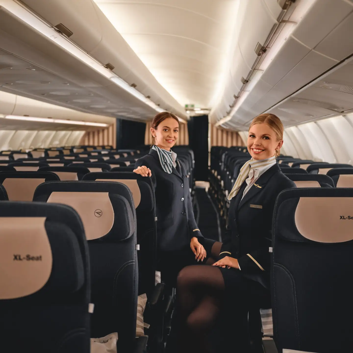 Dos auxiliares de vuelo presentan la comodidad de los asientos en Economy Class