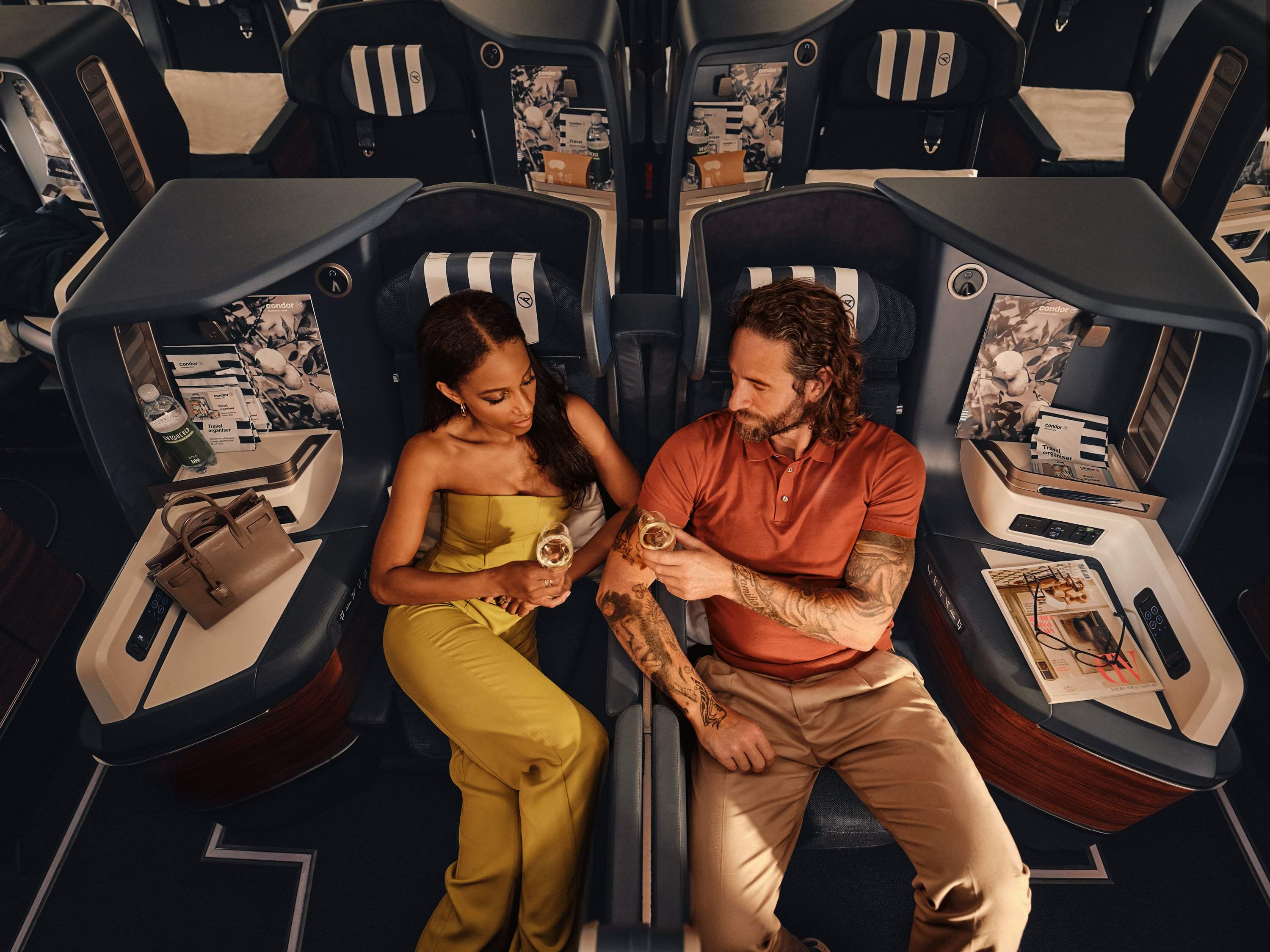 En el Airbus A330neo, una pareja está sentada en asientos Prime Seat de Business Class bebiendo champán.