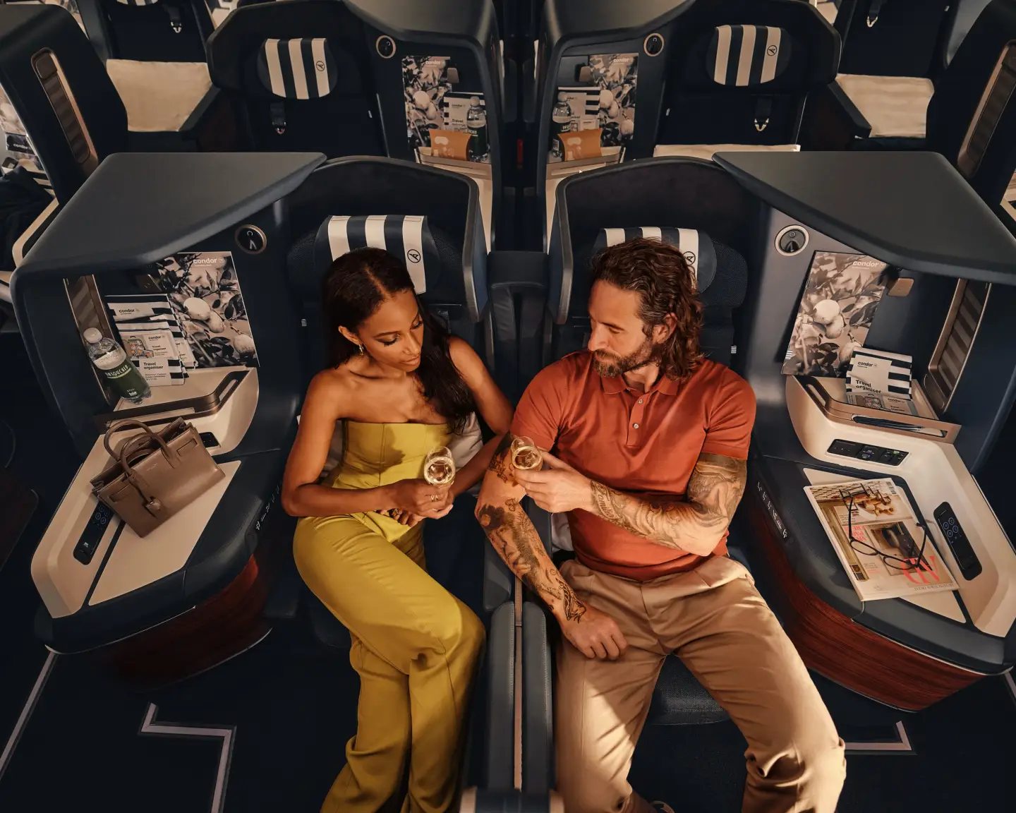 En el Airbus A330neo, una pareja está sentada en asientos Prime Seat de Business Class bebiendo champán.