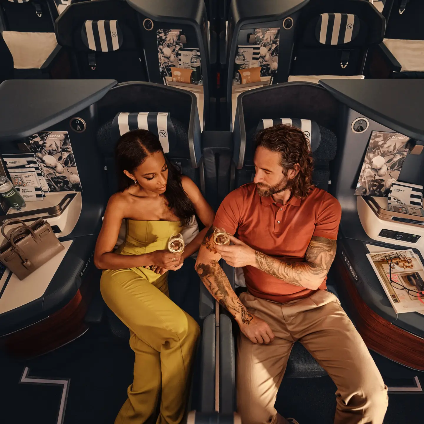 En el Airbus A330neo, una pareja está sentada en asientos Prime Seat de Business Class bebiendo champán.