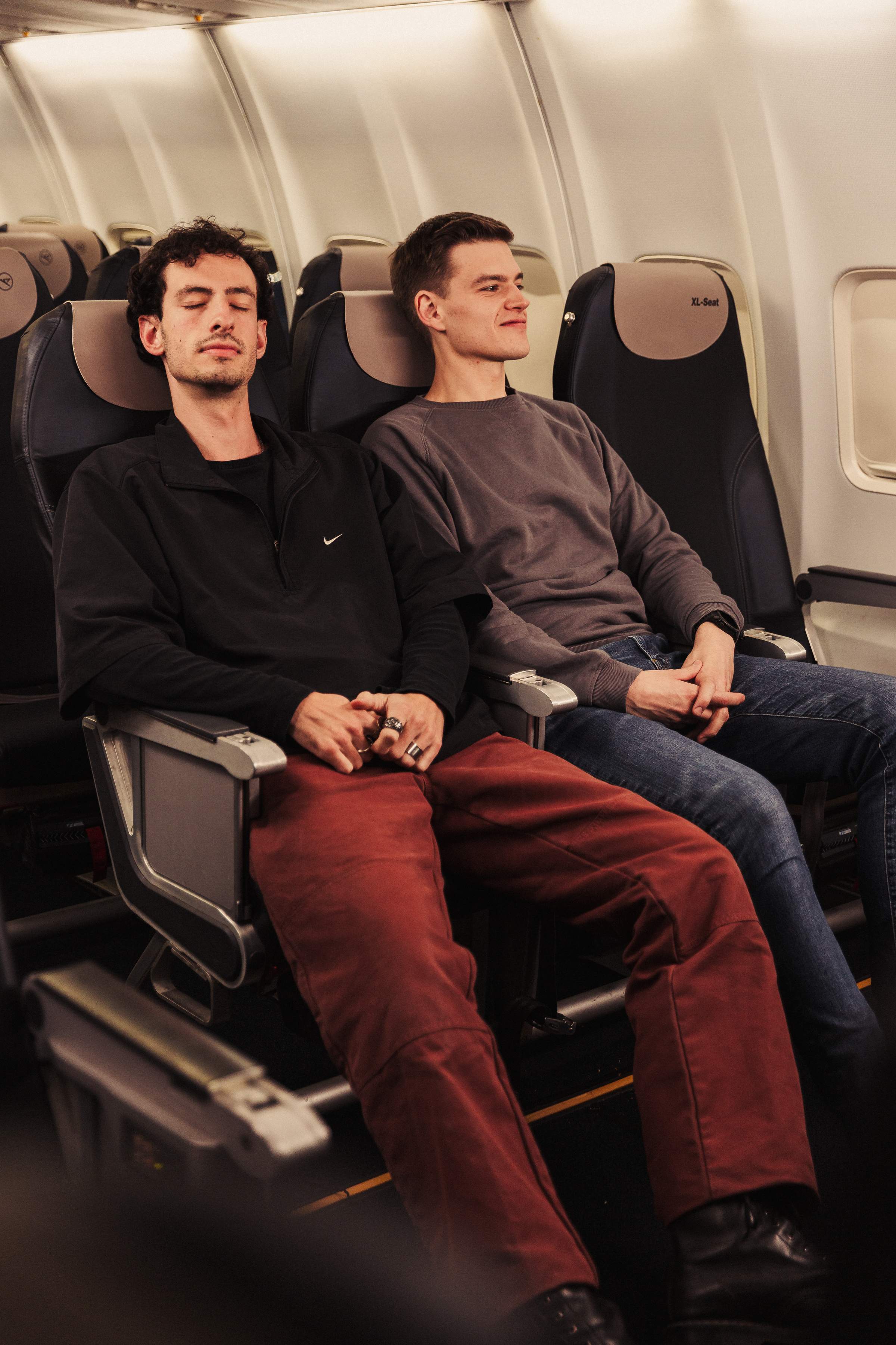 Dos hombres están sentados uno junto al otro en XL Seats