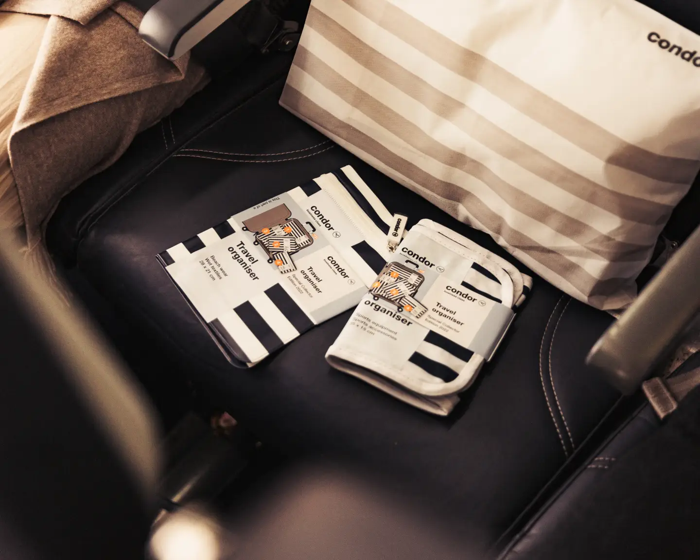 Un organizador de viajes de Condor descansa en un asiento de Economy Class.