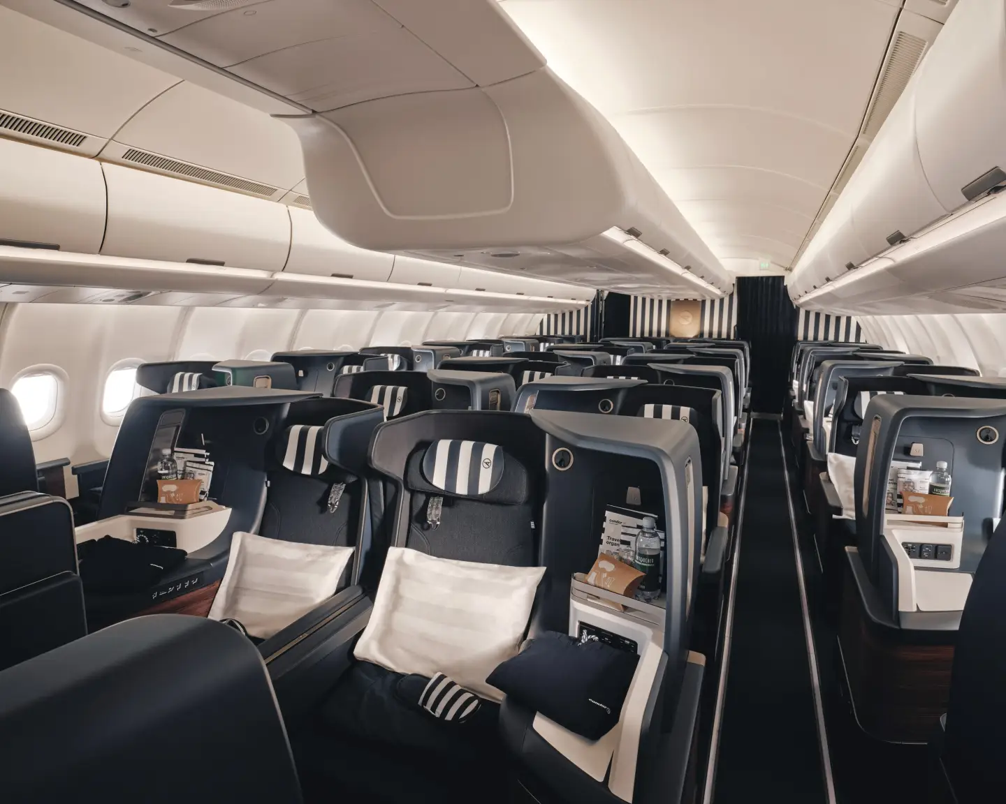 Um Prime Seat vazio na Condor Business Class, com estofos às riscas e painéis azuis.