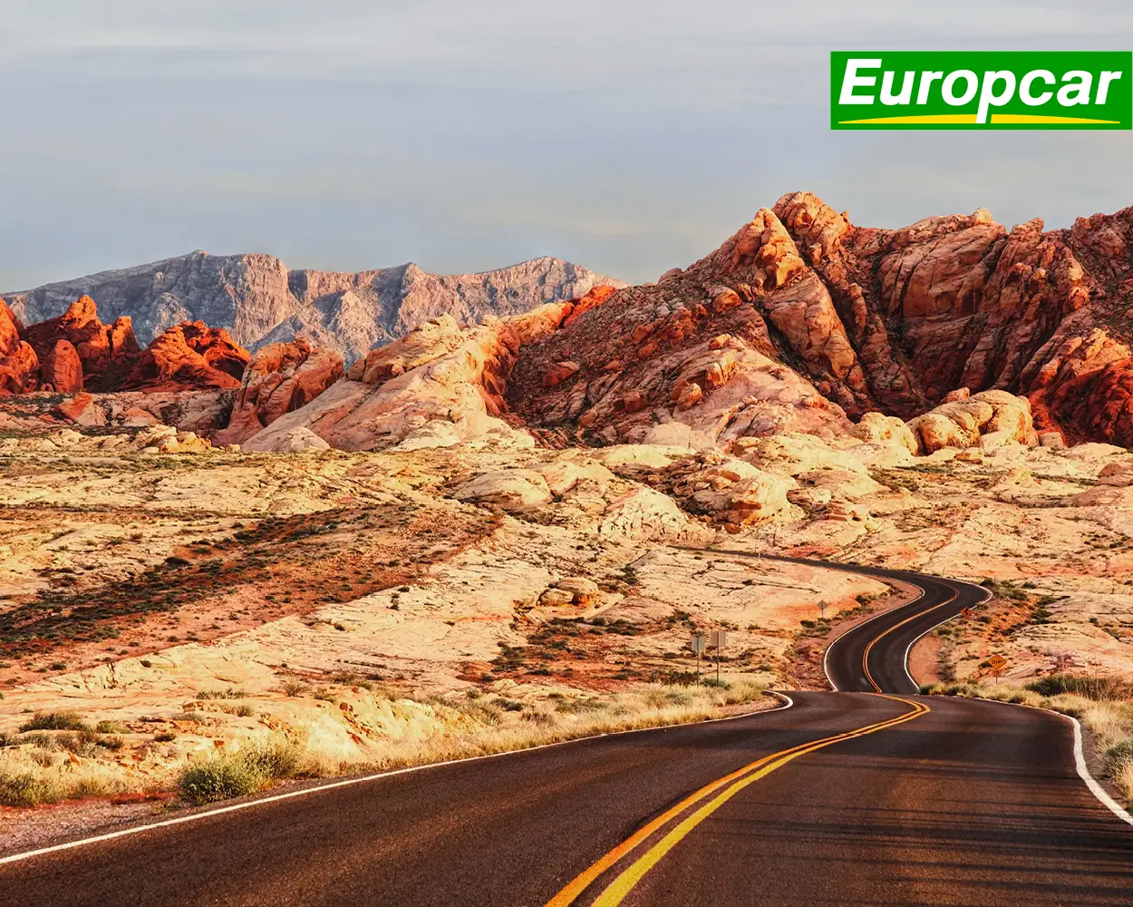 Logotipos de Condor y Europcar en una imagen de una carretera en un parque nacional estadounidense