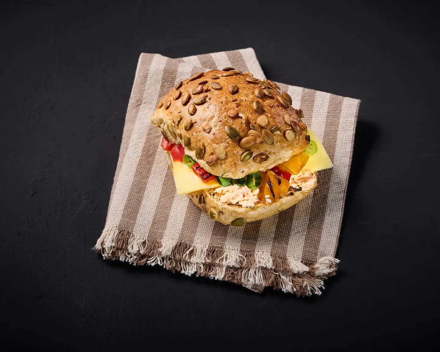 Pumpkin seed roll with cheese, served on a striped napkin