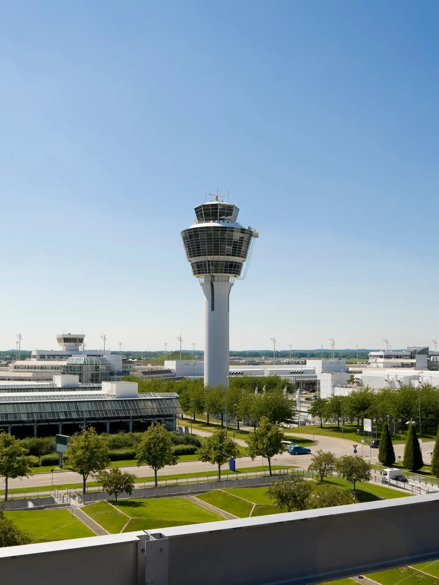 Blick auf den Flughafen München mit Tower, Terminalgebäuden und dem Munich Airport Center.